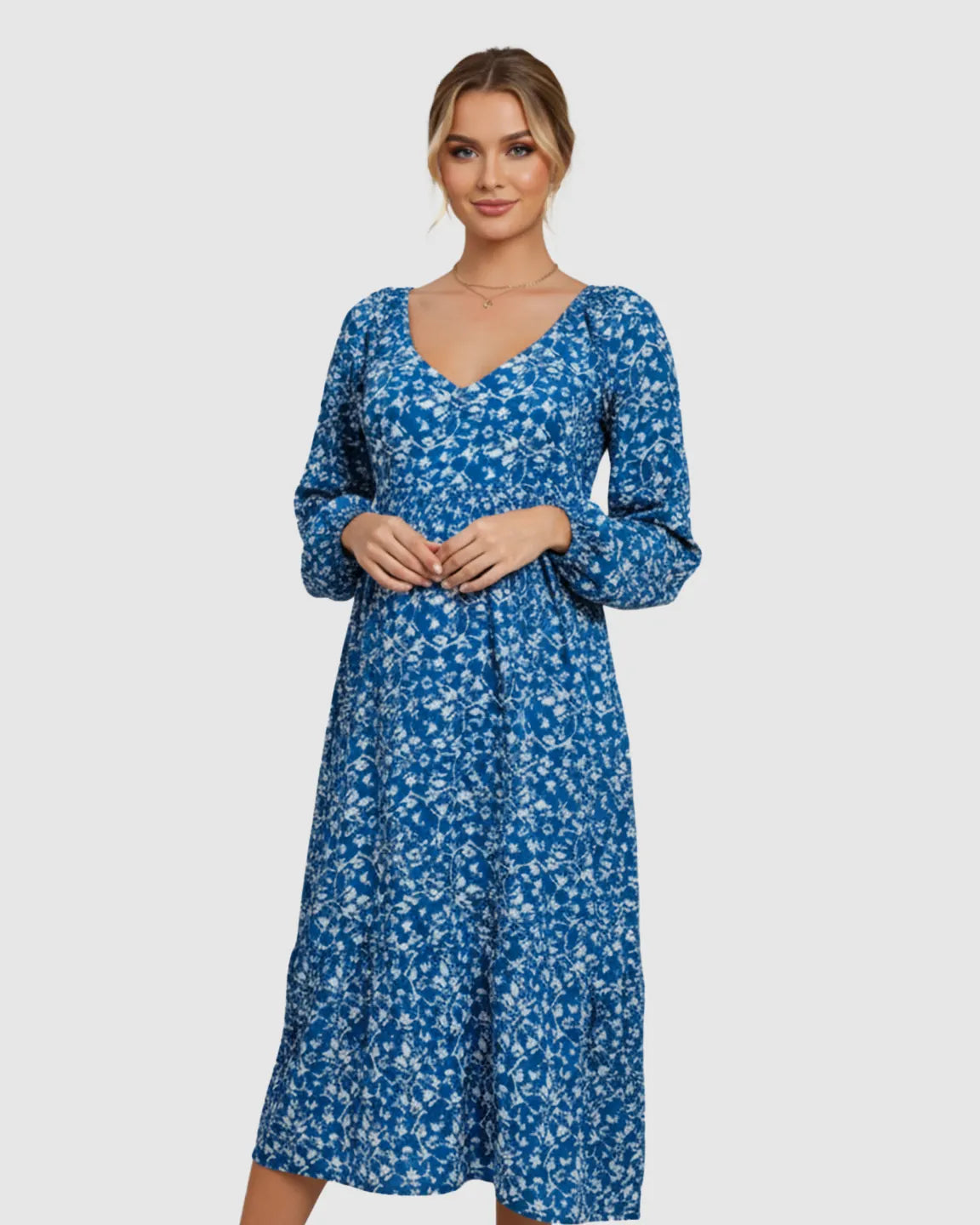 Woman in a blue floral chiffon A-line maternity dress with long balloon sleeves and a V-neck.