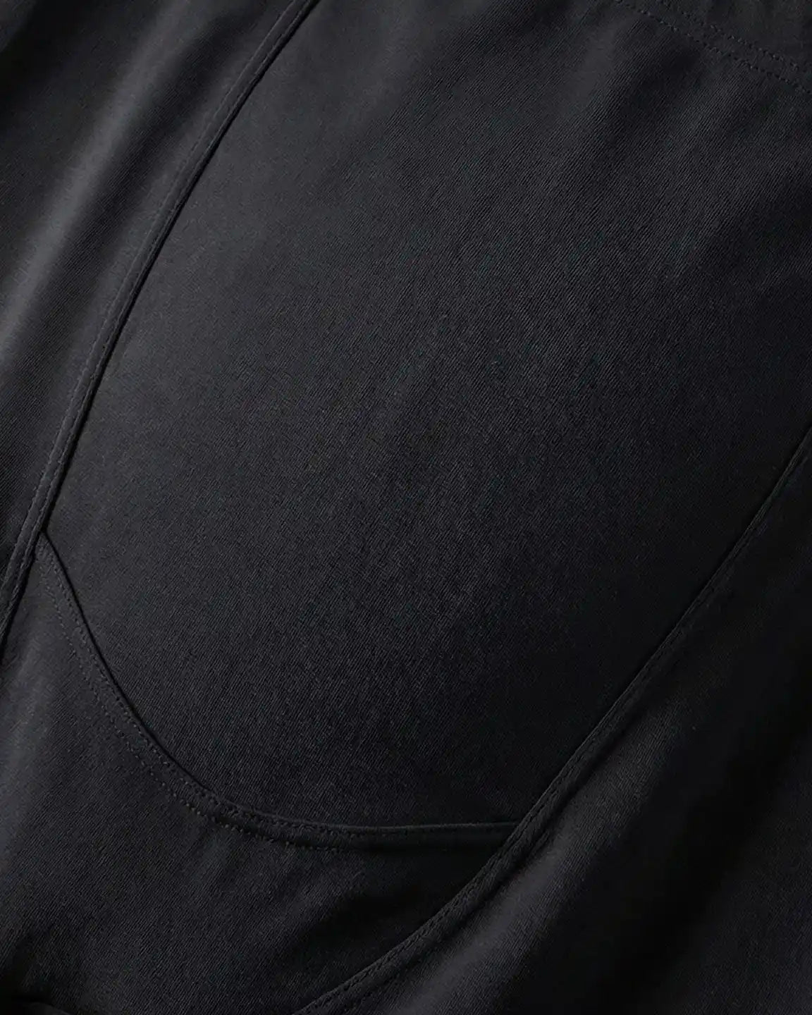 Close-up of black fleece-lined over-bump maternity leggings with visible stitching and soft fabric texture.