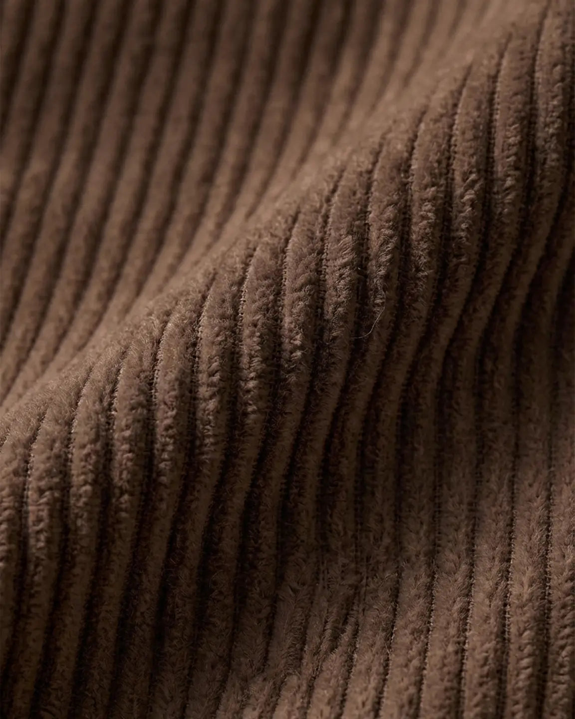 Close-up of brown corduroy fabric, showing its soft texture and ribbed design for maternity overalls.