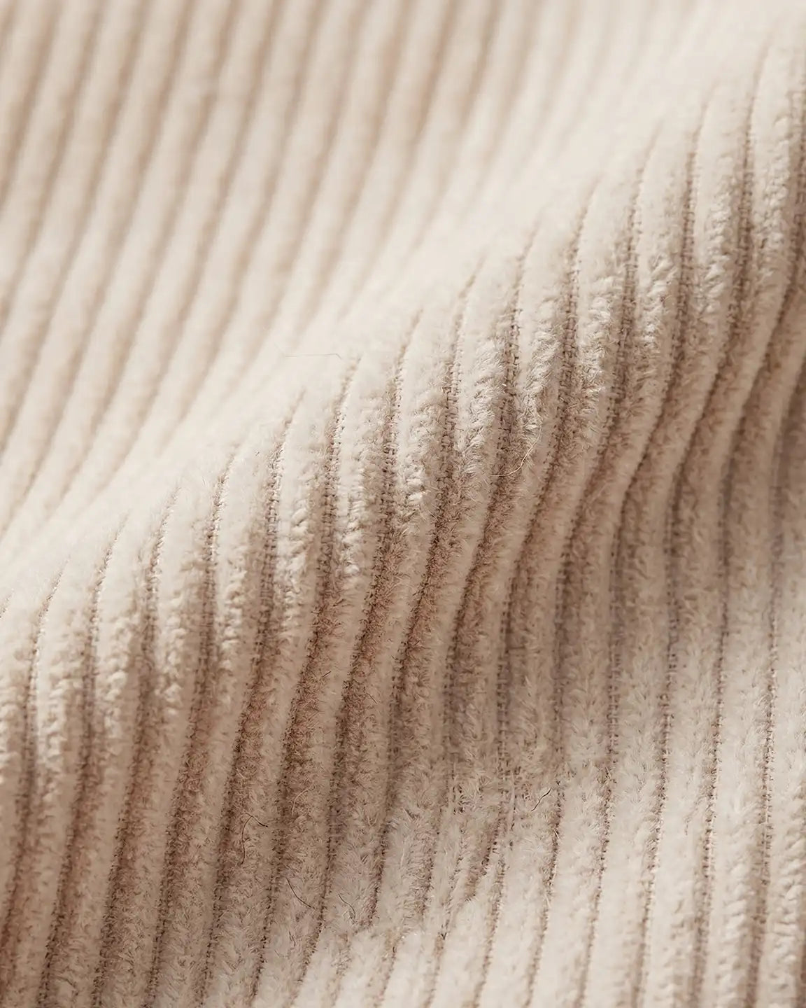 Close-up of soft, ribbed beige corduroy fabric for maternity overalls, showing texture and warmth.