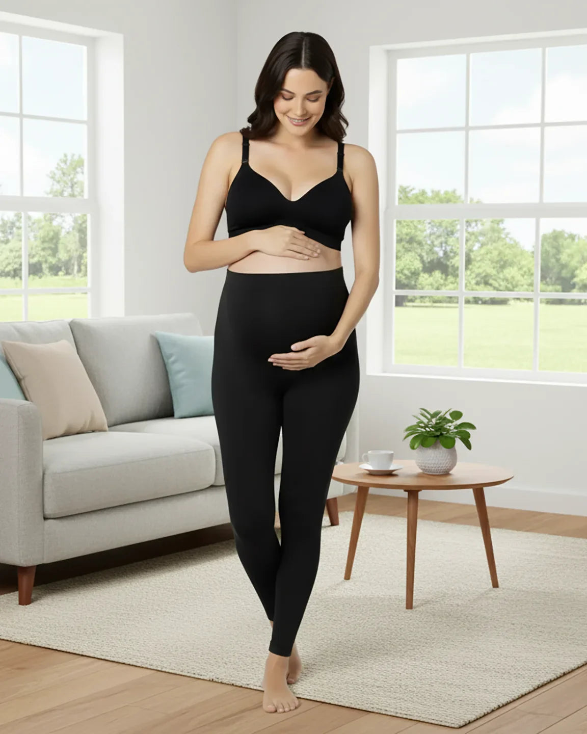 Smiling pregnant woman wearing black Bump Society Belly Support Stretch Maternity Leggings and a matching bra.