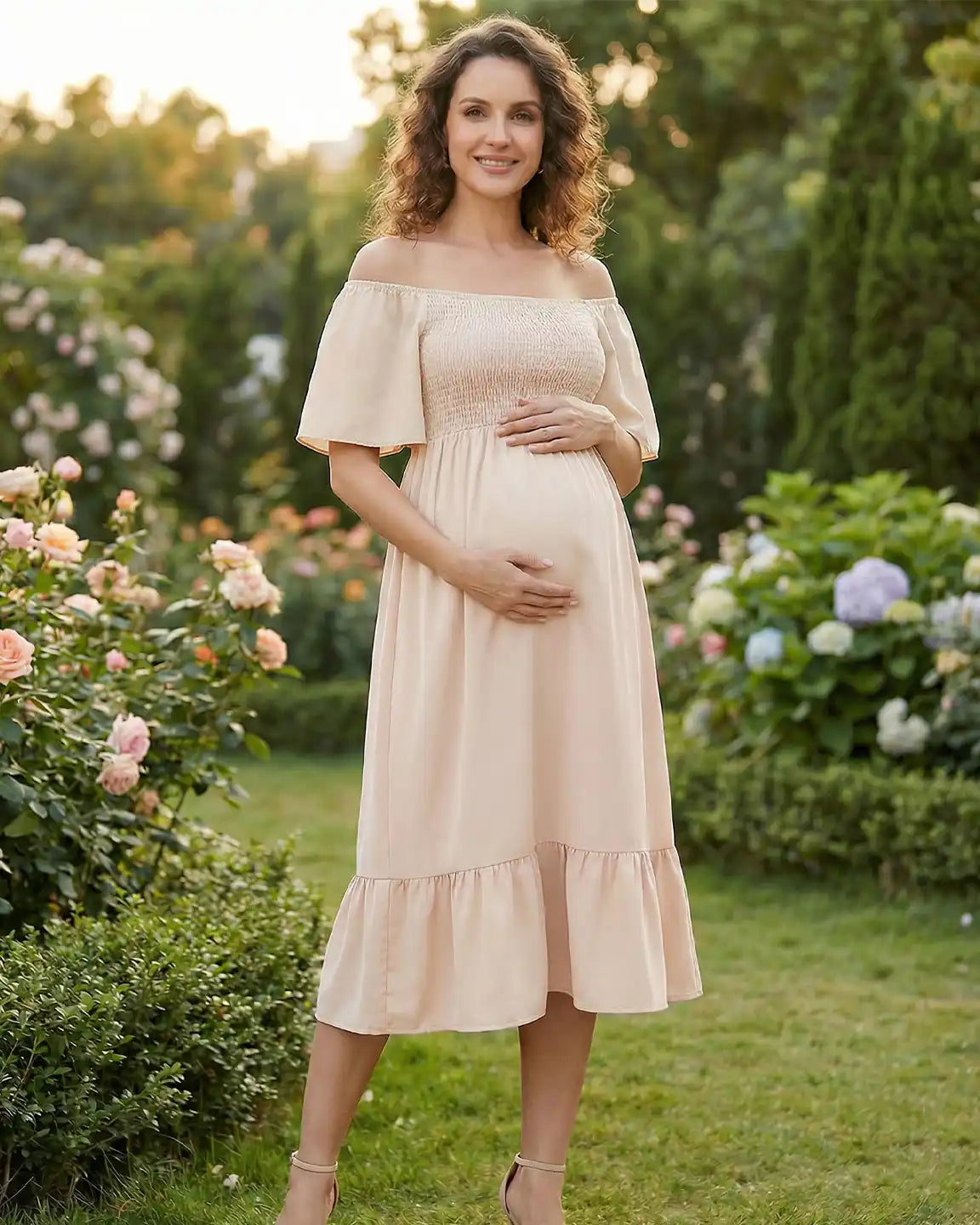 Smiling pregnant woman in a light peach off-shoulder flutter-sleeve smocked maternity midi dress.