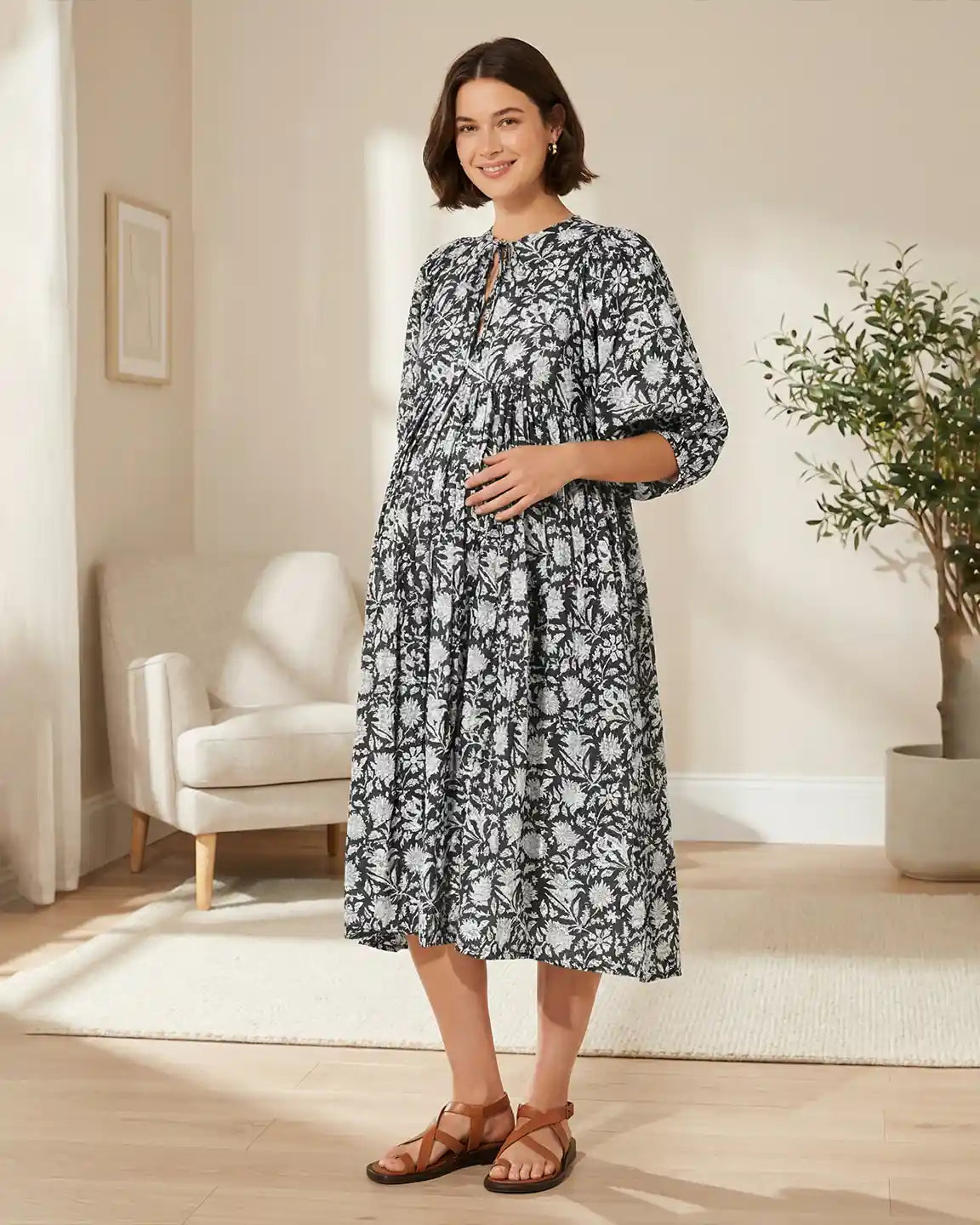 Maternity midi dress: black and white floral print, gathered shoulders, loose fit, puff sleeves, round neckline.