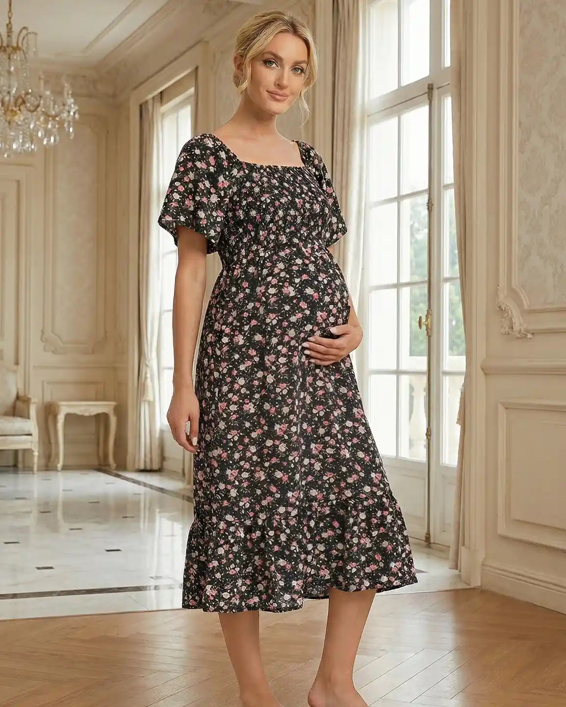Pregnant woman in black floral flutter-sleeve smocked maternity midi dress with pink flowers.