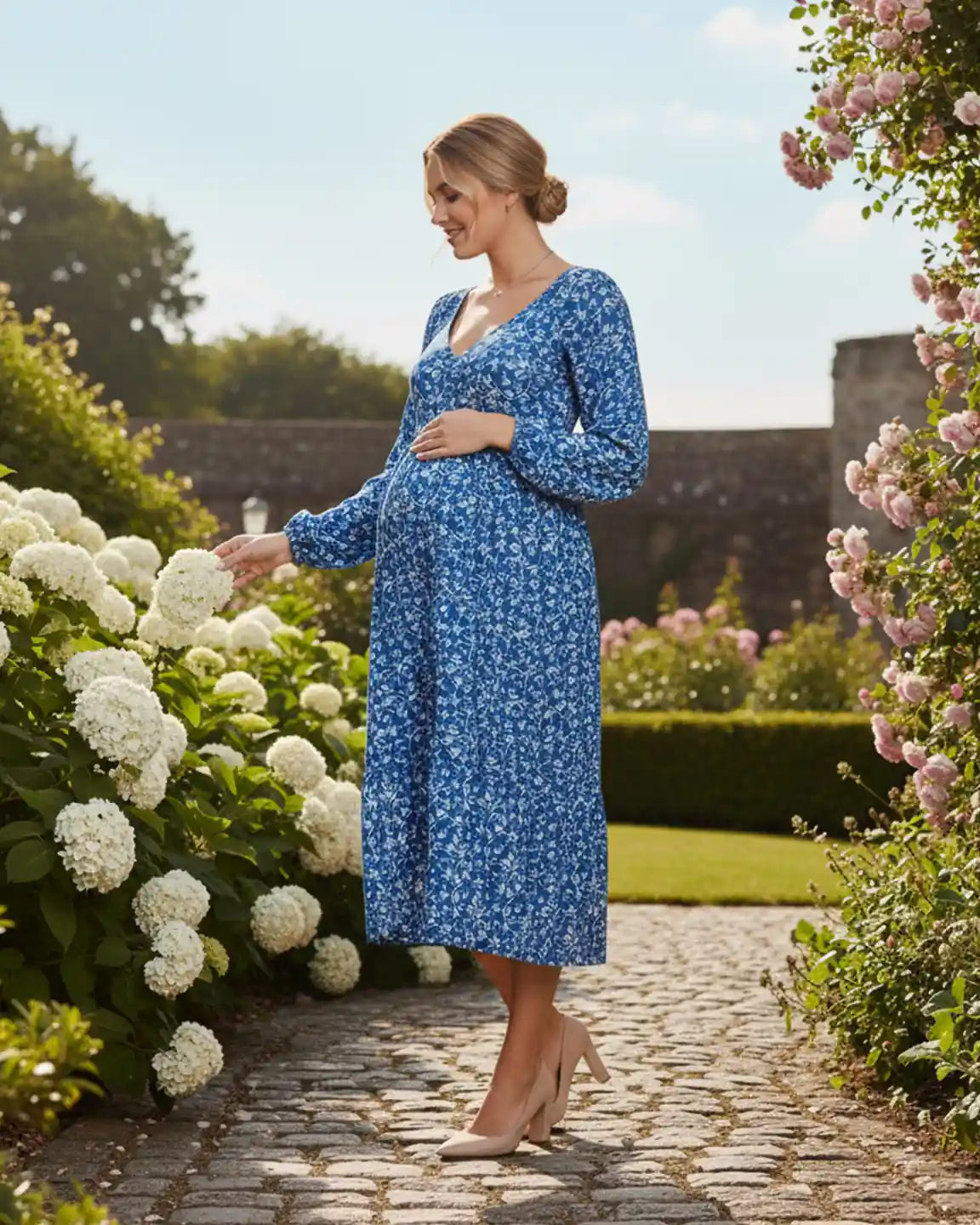 Blue floral balloon-sleeve A-line maternity dress in chiffon, worn by a pregnant woman in a garden.