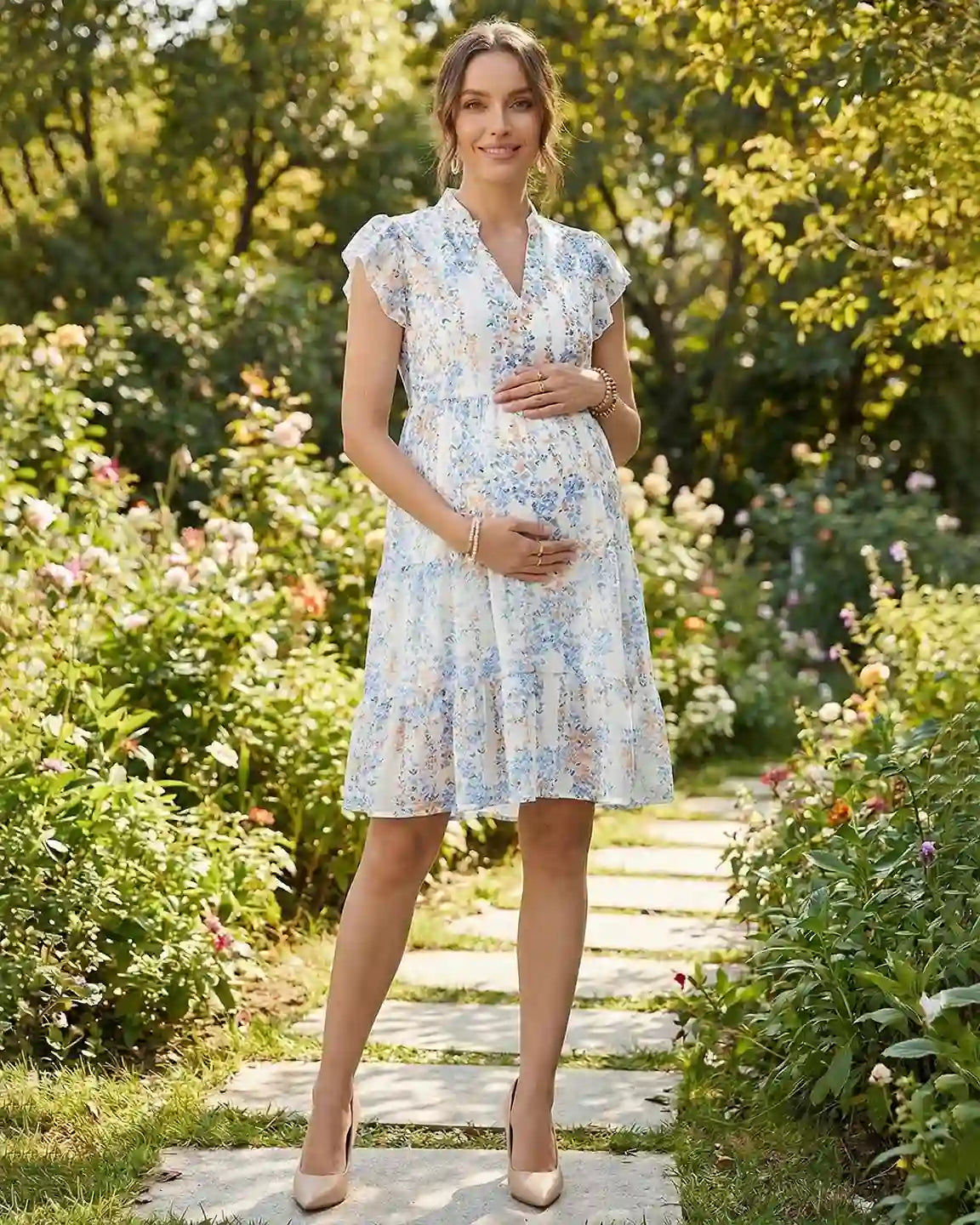 Maternity dress: white chiffon A-line with blue/yellow floral print, flutter sleeves, and V-neck, worn by a pregnant woman.