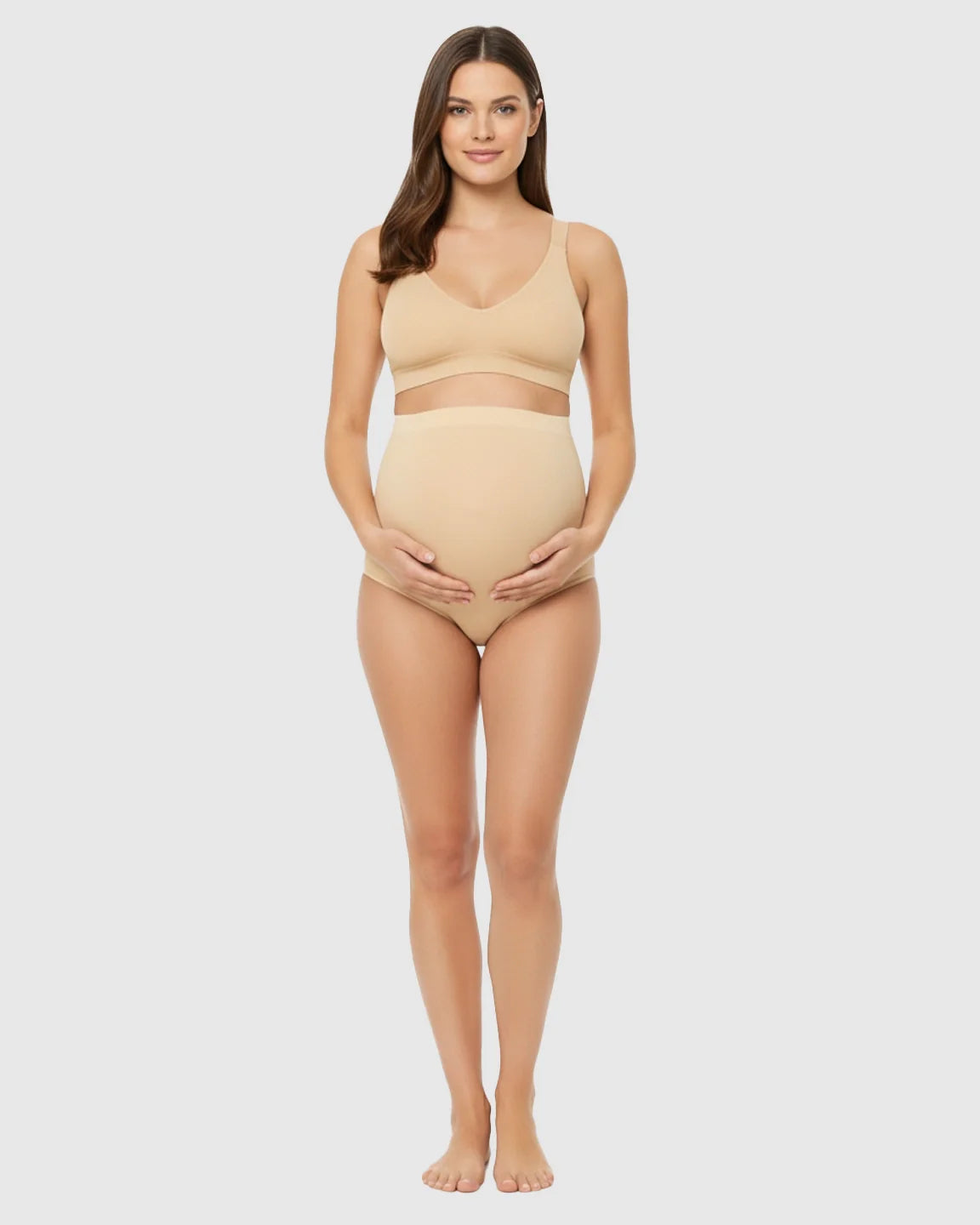 Pregnant woman in seamless nude high-waist belly-support maternity underwear and matching bra.