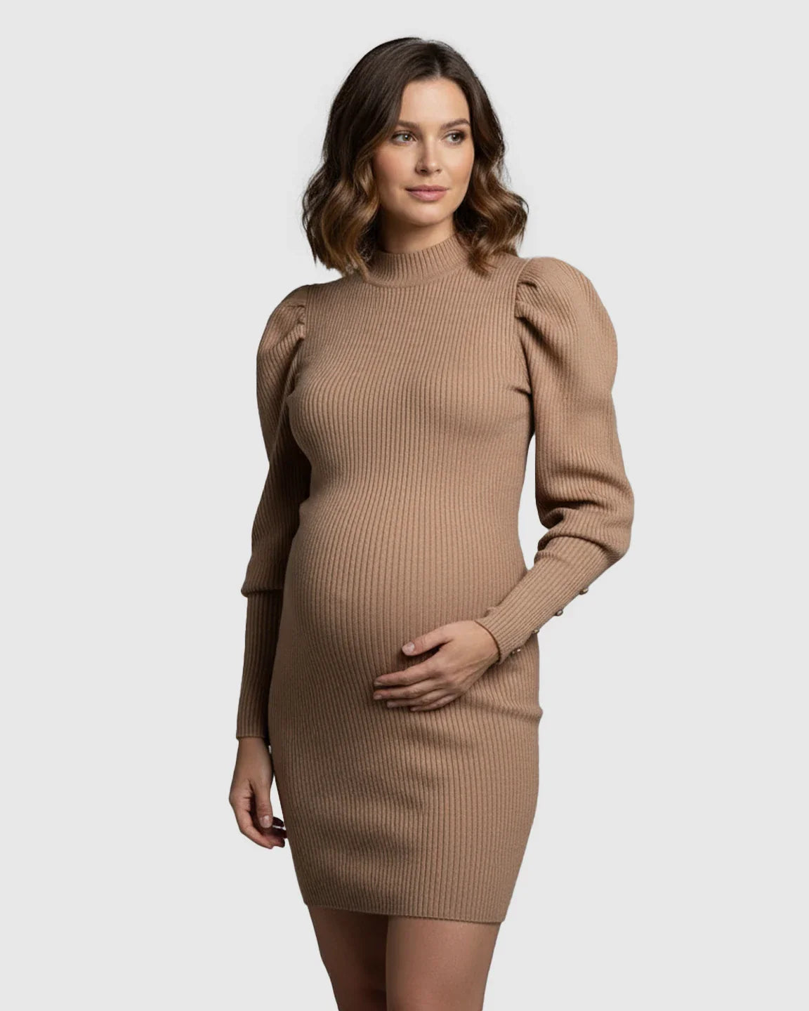 Pregnant woman in a tan ribbed knit bodycon puff sleeve maternity short dress, hand on belly.