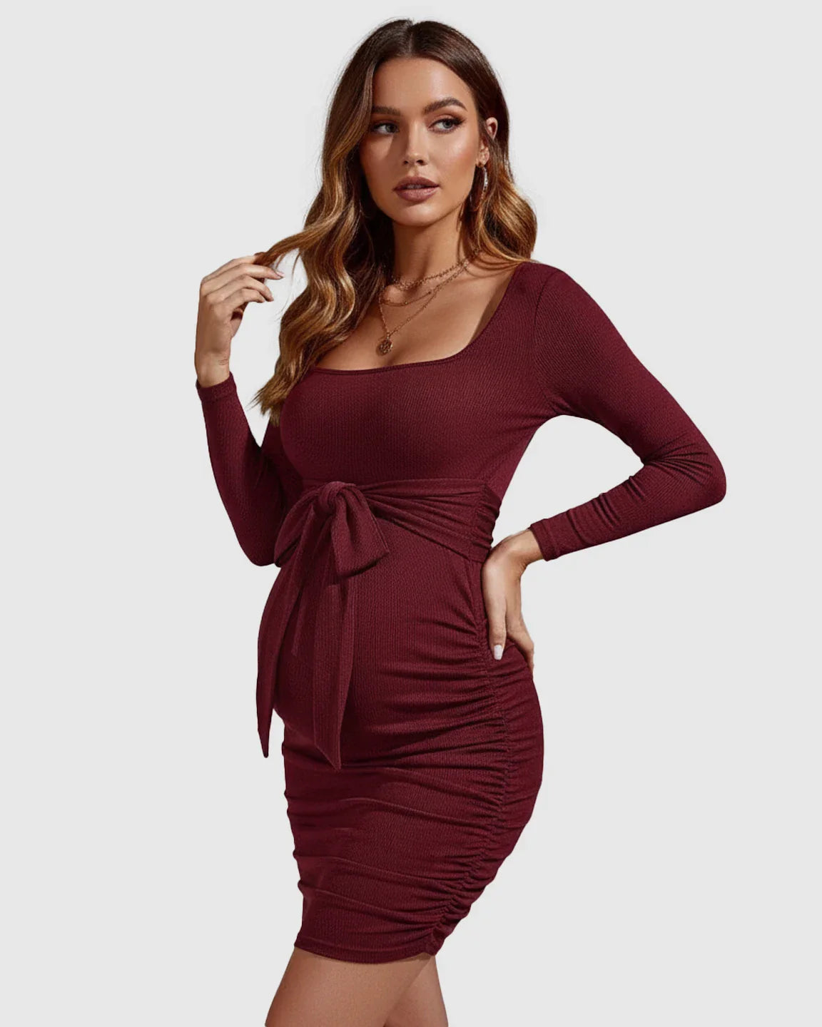 Maternity bodycon mini dress in burgundy with square neckline, long sleeves, tie-waist, and side ruching.