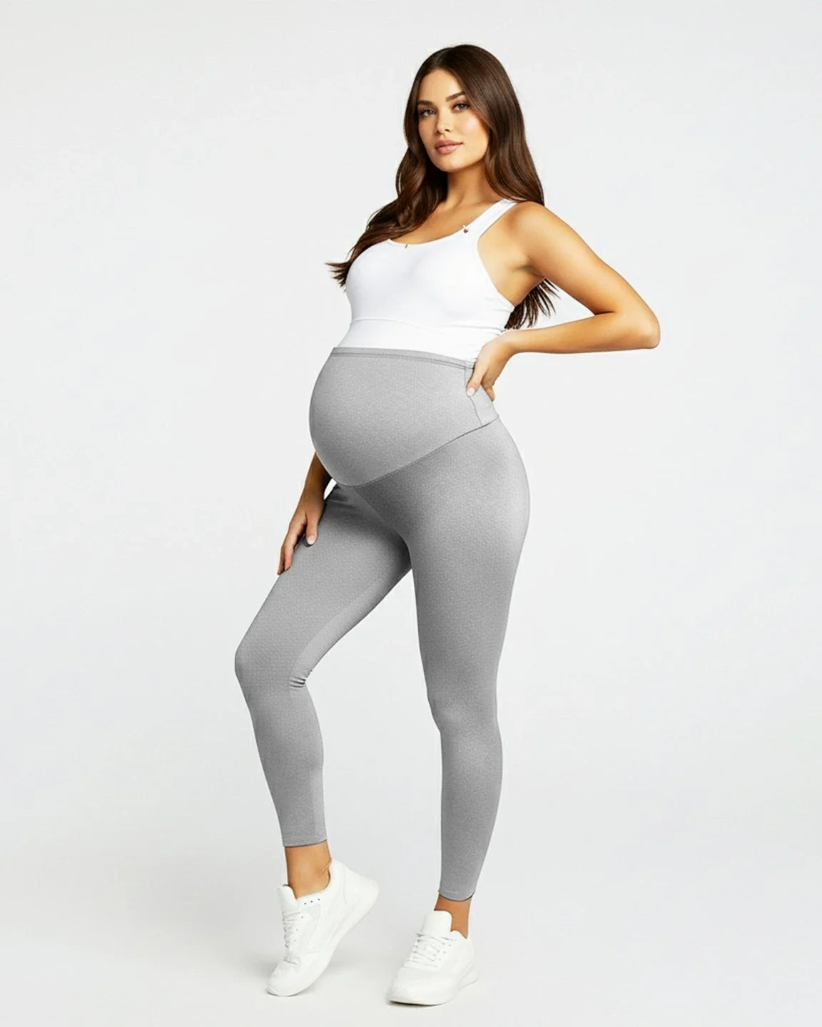 Pregnant woman in light gray sculpting ankle-length maternity leggings with a supportive over-the-bump waistband.