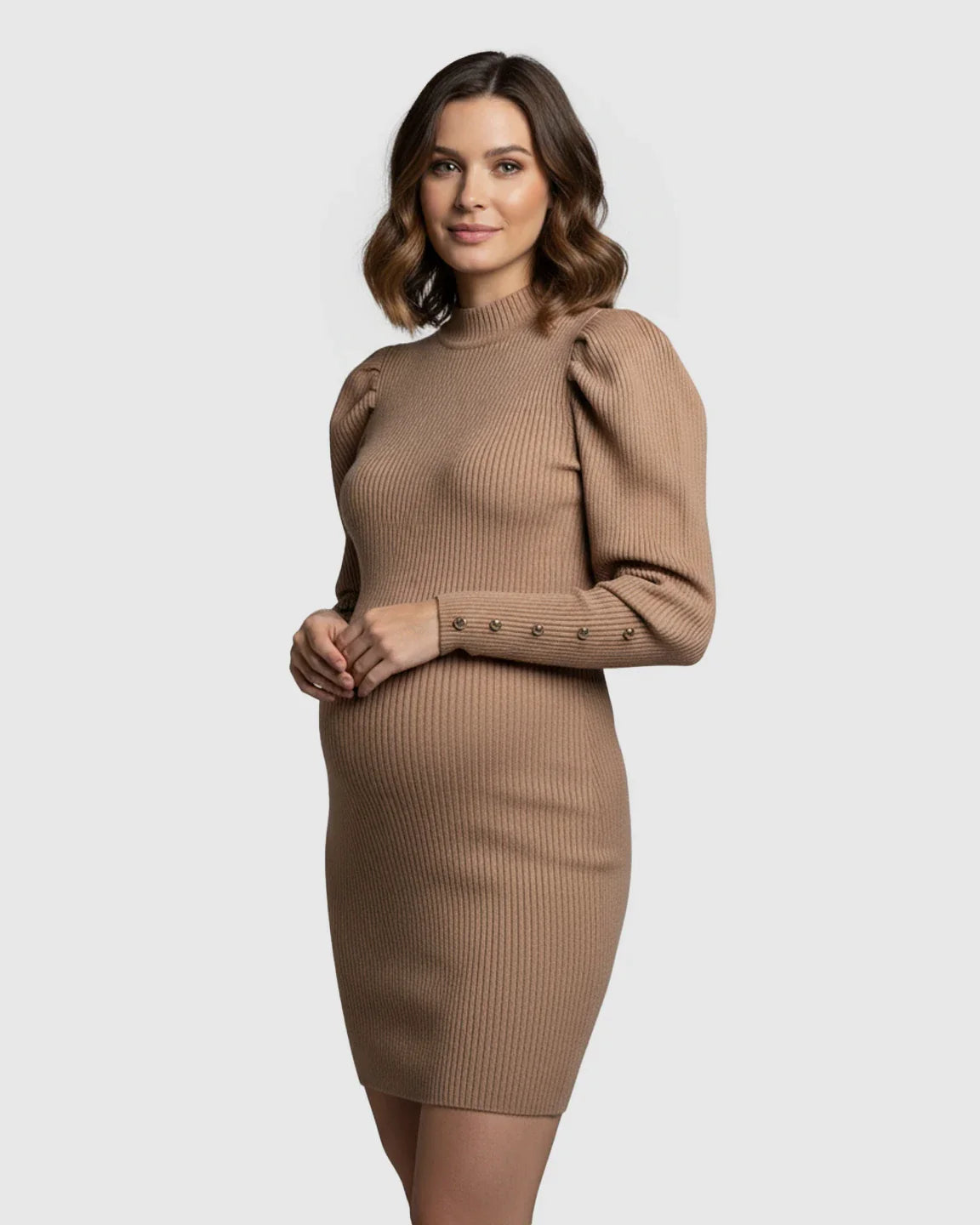 Pregnant woman in a tan ribbed knit bodycon maternity dress with puff sleeves and gold button cuffs.