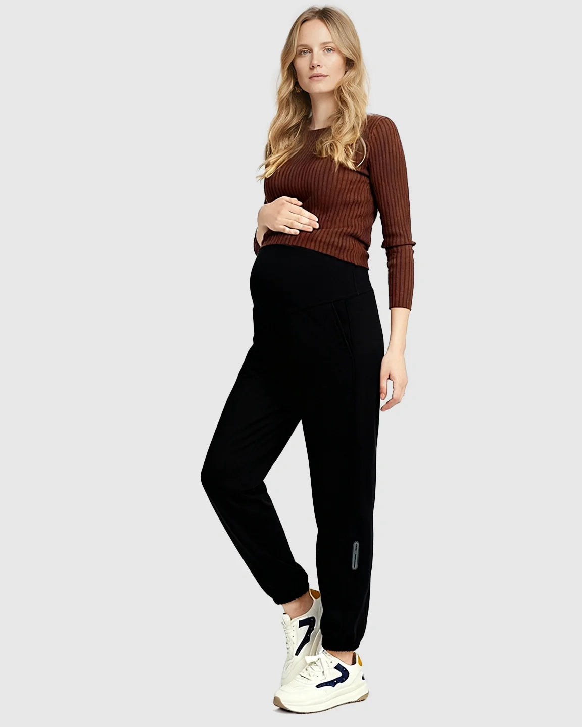 Pregnant woman in black soft knit maternity joggers with a supportive waistband and side pockets.