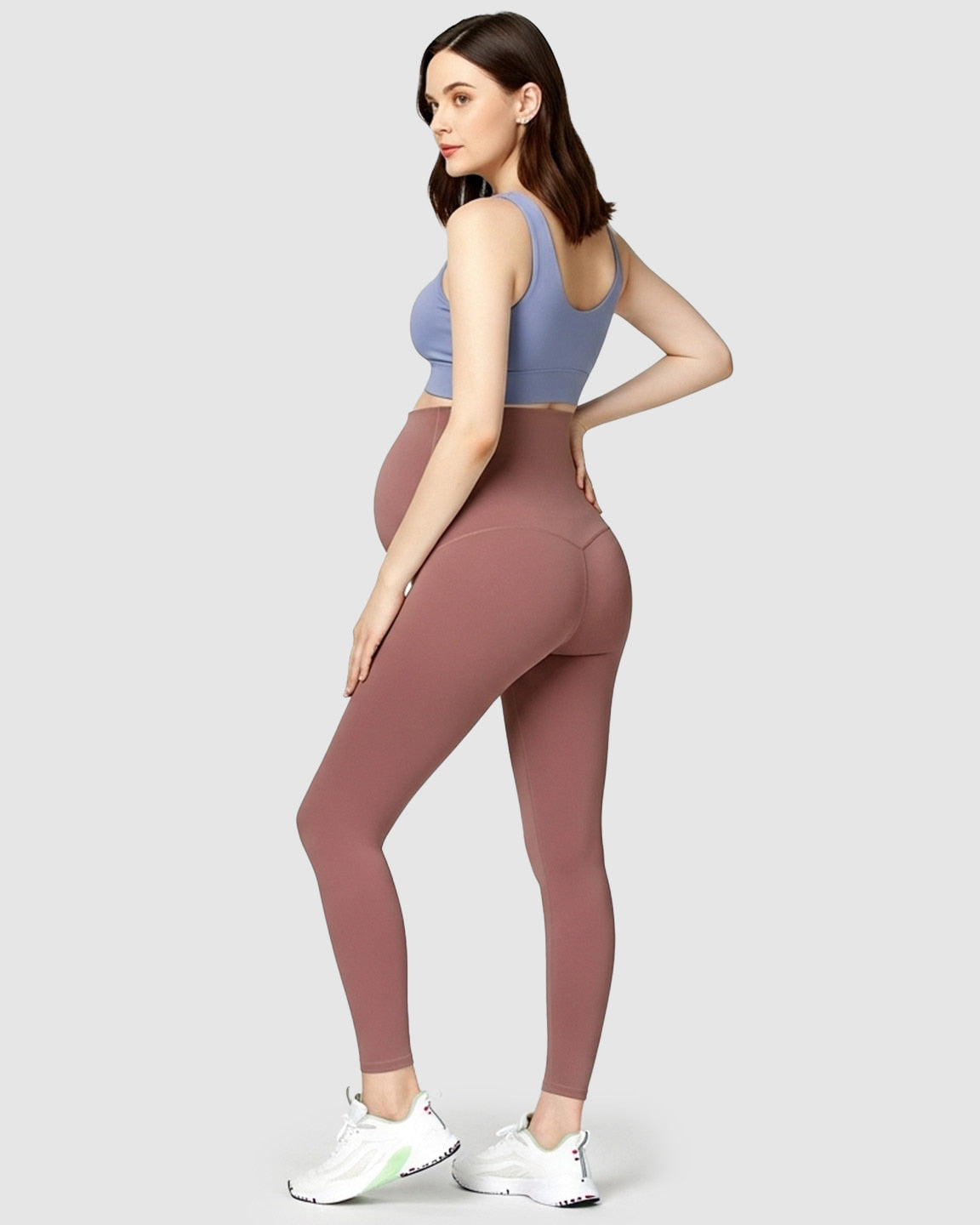 Maternity model in high-waist dusty rose soft stretch leggings and a periwinkle sports bra, showcasing bump support.