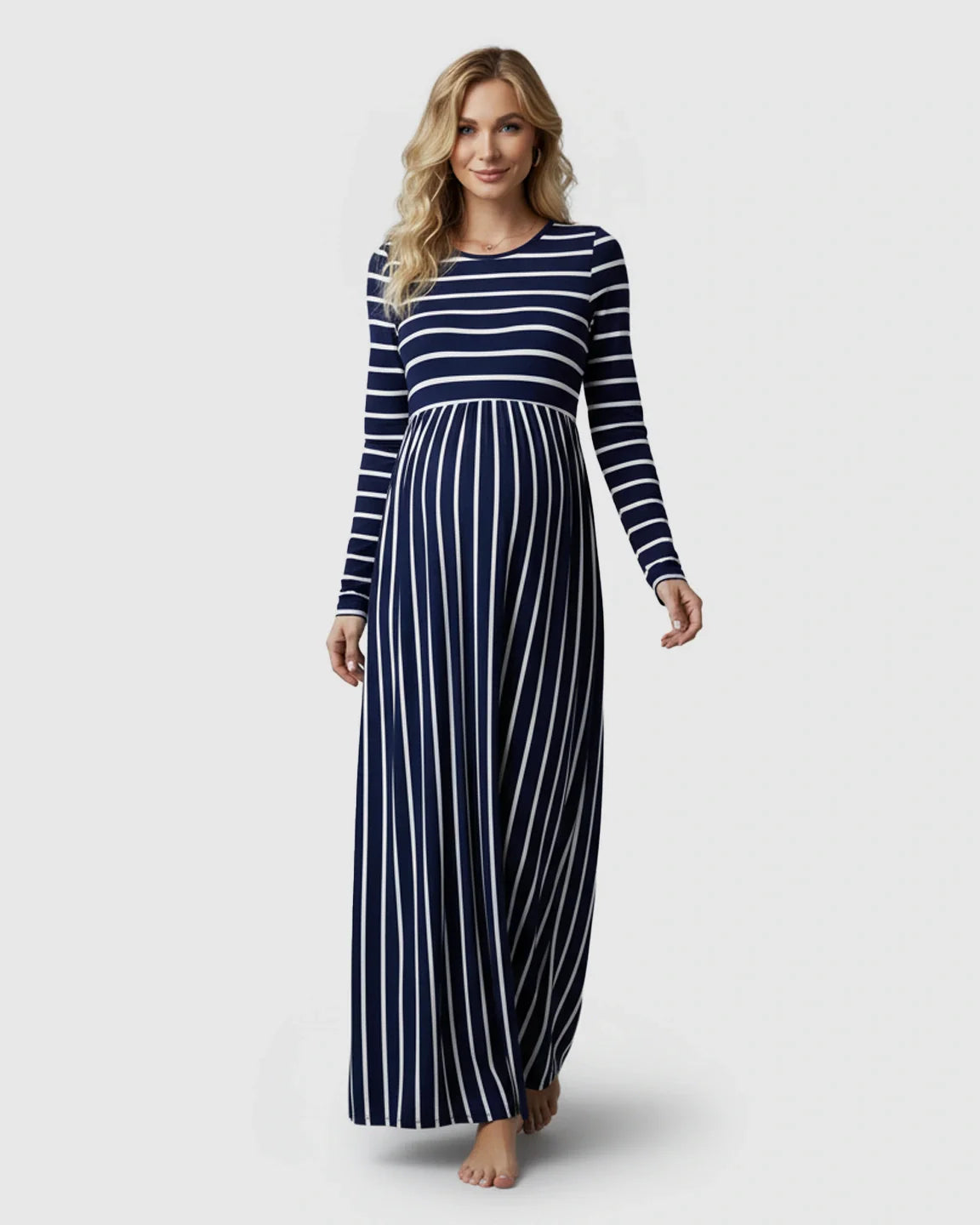 Smiling pregnant woman in a navy and white striped long sleeve maternity maxi dress.