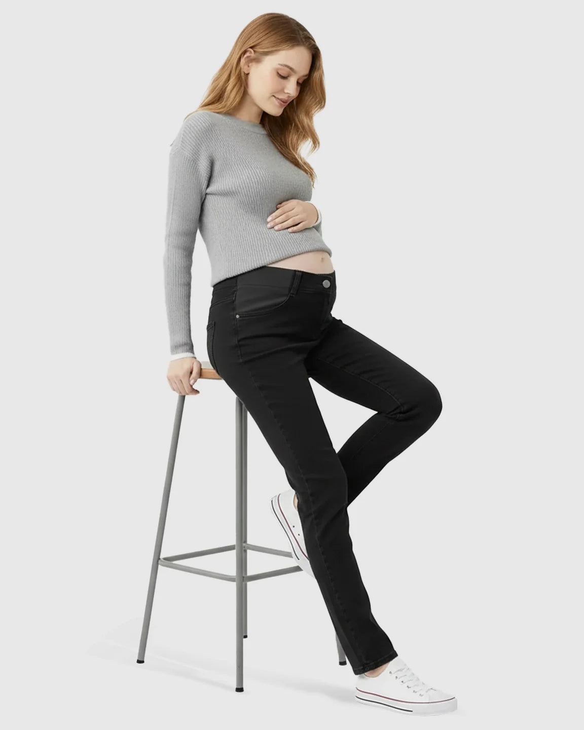 Pregnant woman in black straight-leg maternity jeans with side panels and a grey sweater.