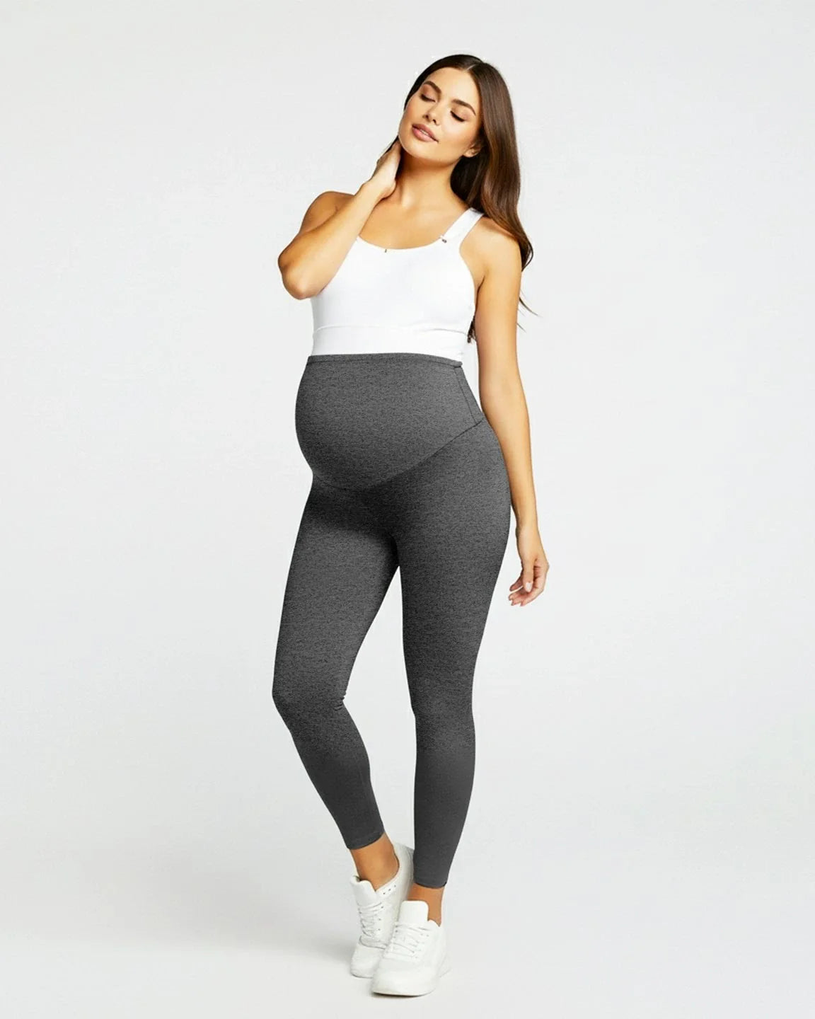Pregnant woman in dark gray sculpting ankle-length maternity leggings with an over-the-bump panel.