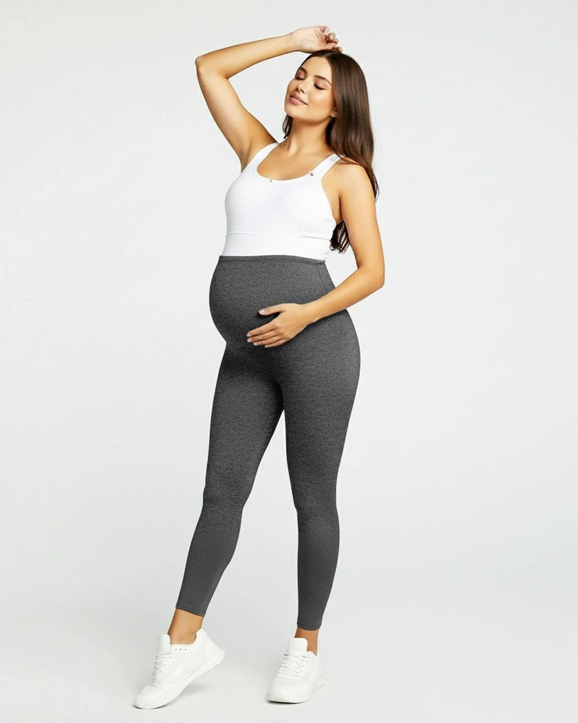 Pregnant woman in dark gray sculpting ankle-length maternity leggings with an over-the-bump waistband.
