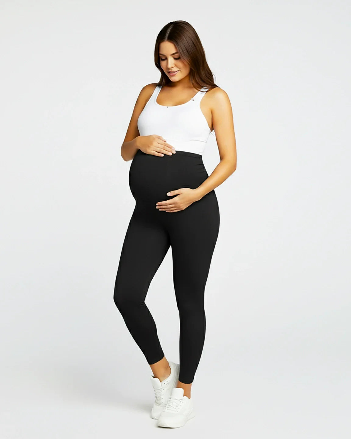 Pregnant woman in black sculpting ankle-length maternity leggings with an over-the-bump panel.