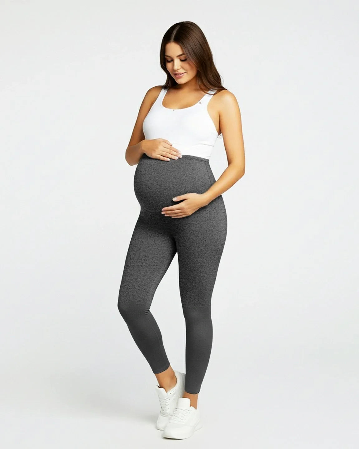 Pregnant woman in dark gray sculpting ankle-length maternity leggings with an over-the-bump waistband.