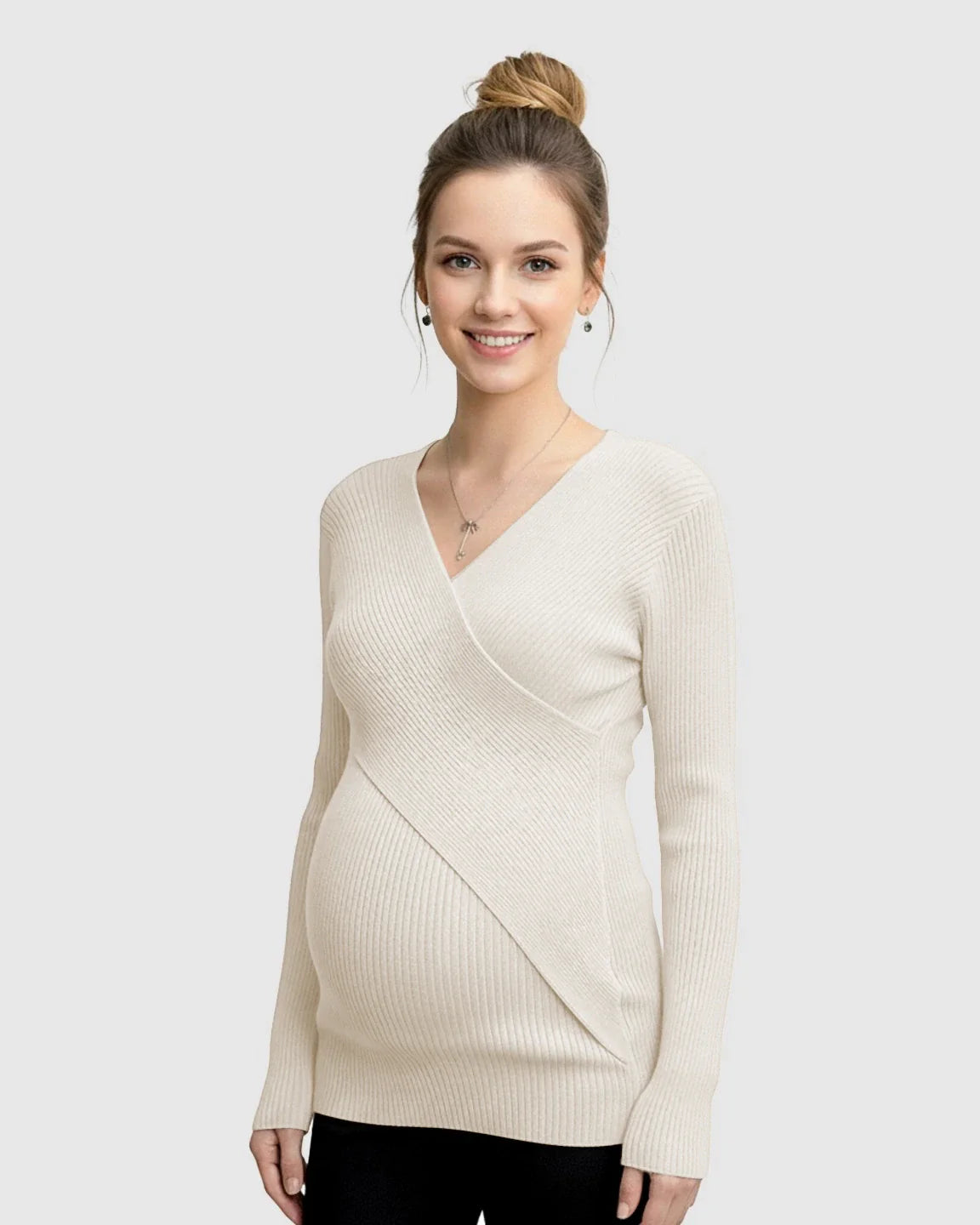 Smiling pregnant woman in a cream faux-wrap ribbed maternity top with long sleeves.