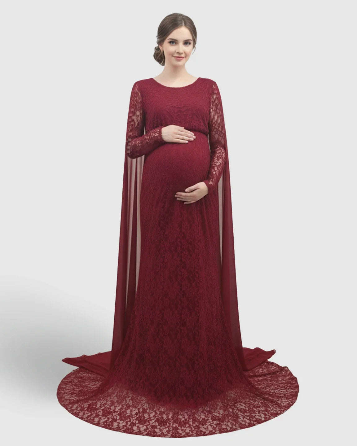 Pregnant woman in a long-sleeved, dark red lace maternity gown with a trailing cape and empire waist.