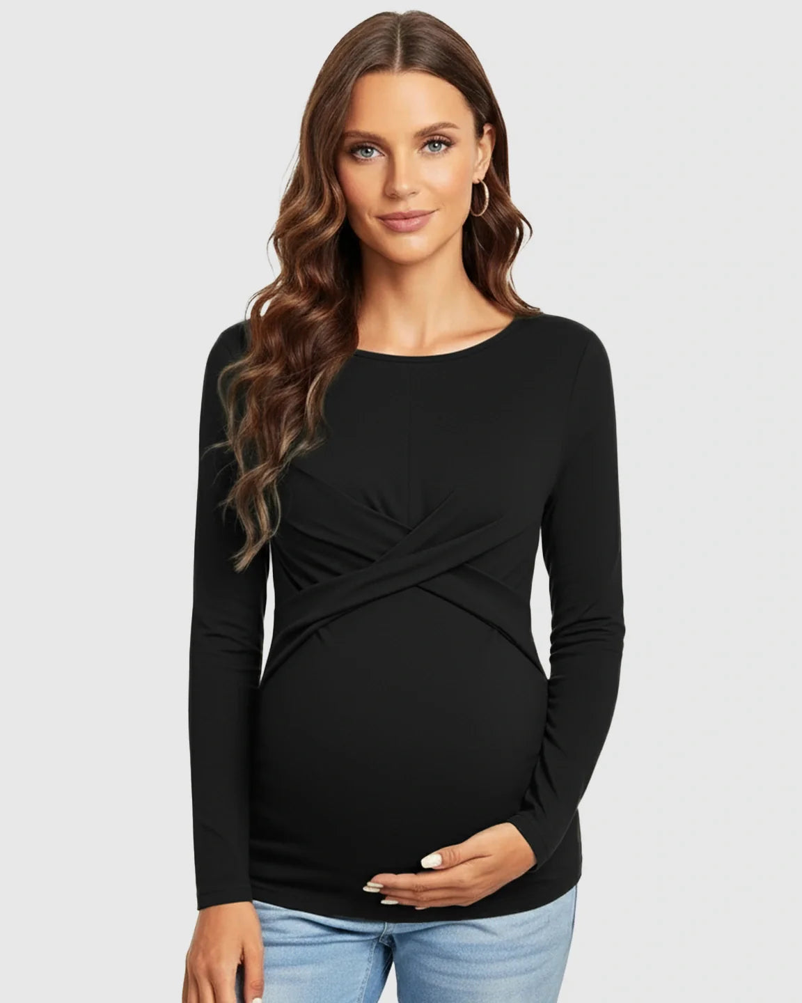 Maternity model in black cross-pleat fitted long sleeve top, round neck, holding bump.