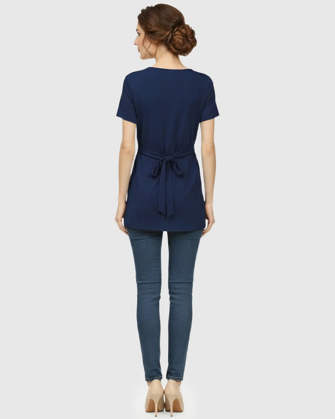 Back view of a model wearing a navy blue V-neck wrap-style maternity top with a tied waist.