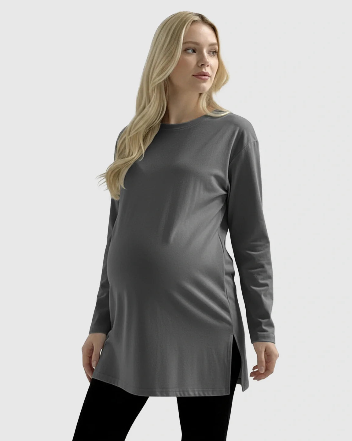 Blonde pregnant woman wearing a charcoal gray long-sleeve cotton maternity top with side slits.