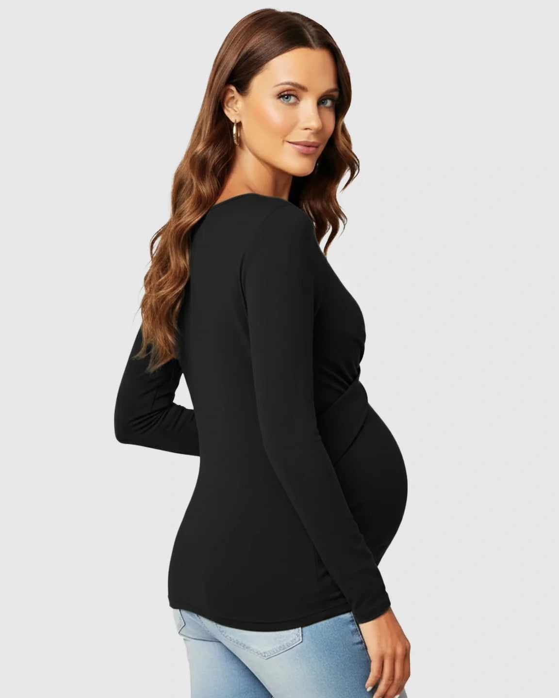 Maternity model in black cross-pleat fitted long sleeve top, highlighting her bump.
