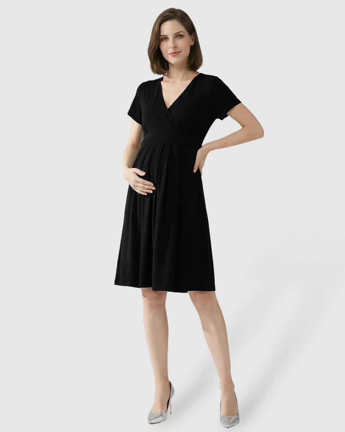 Black V-neck A-line maternity and nursing dress with short sleeves, worn by a pregnant woman.