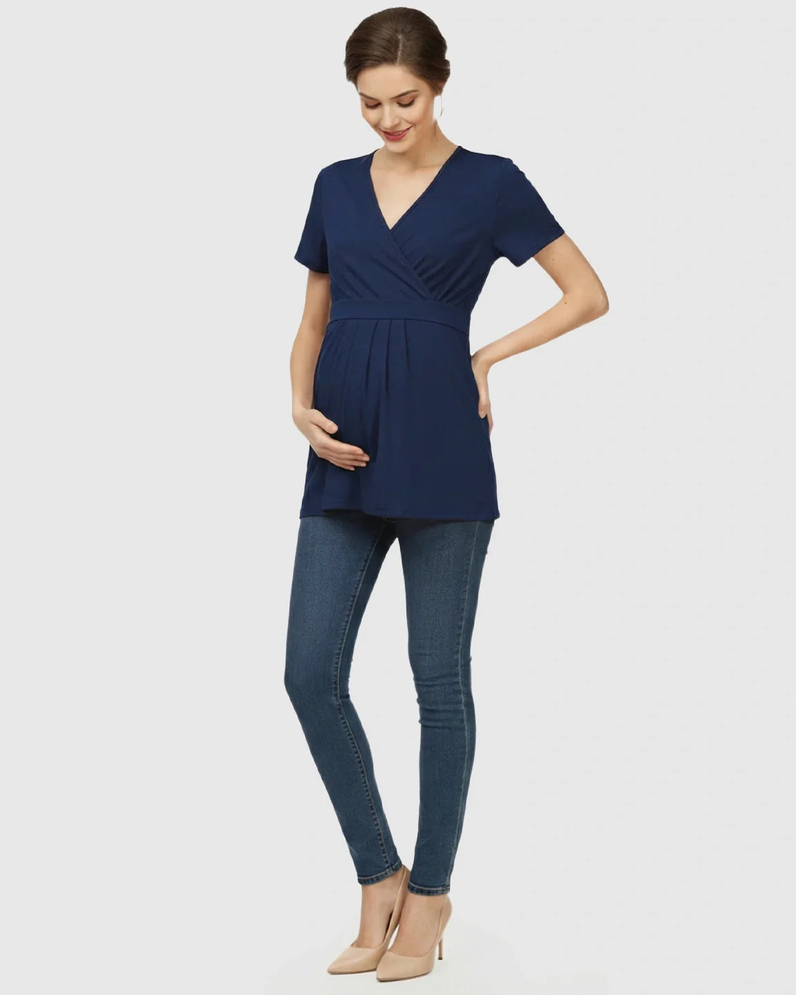 Pregnant woman in a navy V-neck wrap-style maternity top with short sleeves and an adjustable waist tie.