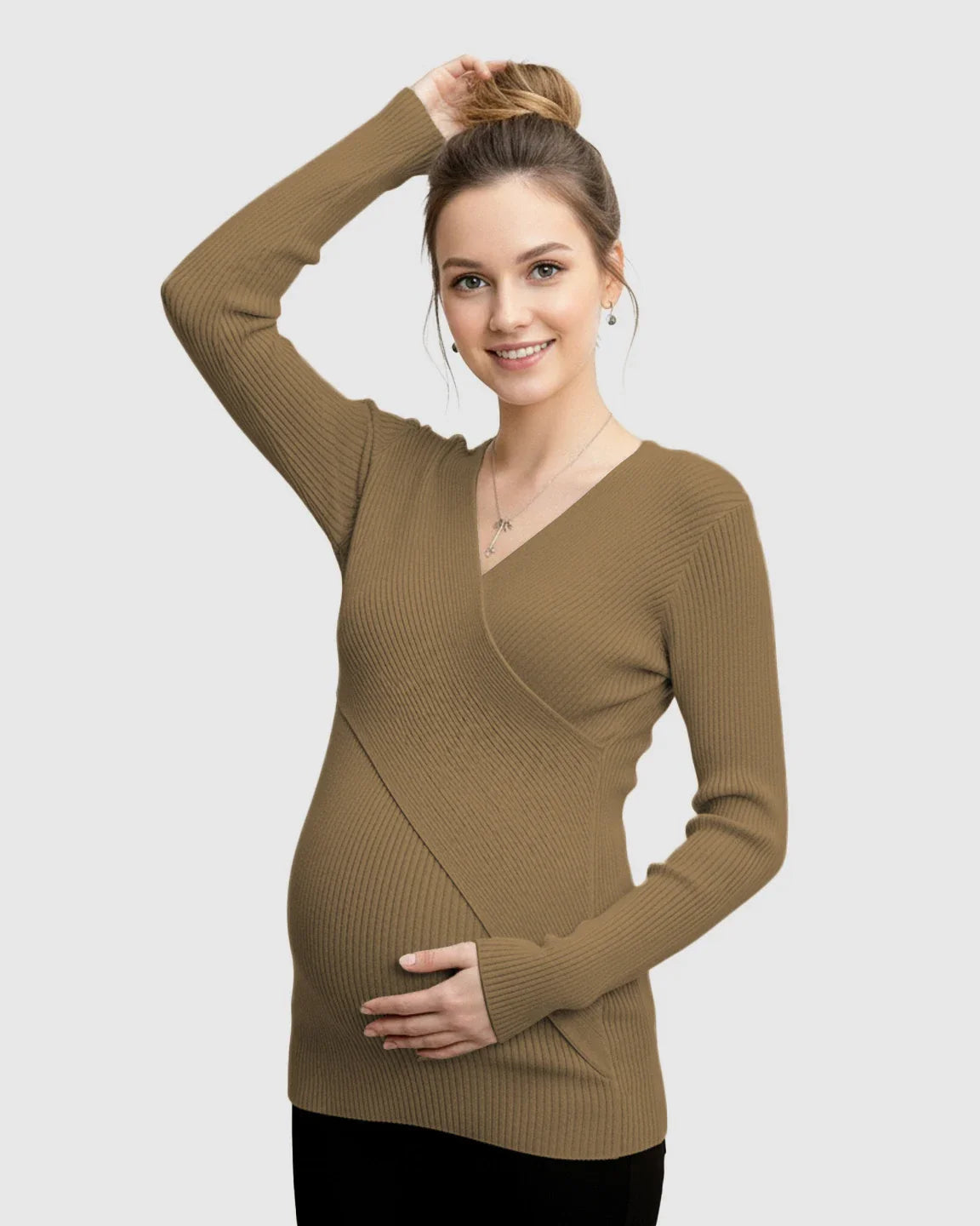 Smiling pregnant woman in a brown faux-wrap ribbed maternity top, hands on head and bump.