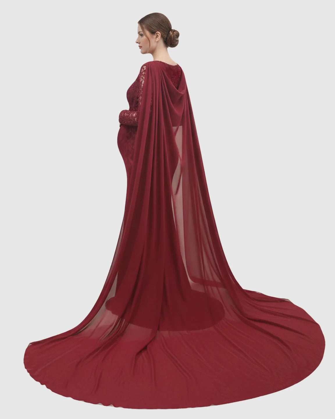 Red lace maternity gown with long sleeves, empire waist, and a flowing chiffon cape trailing behind.