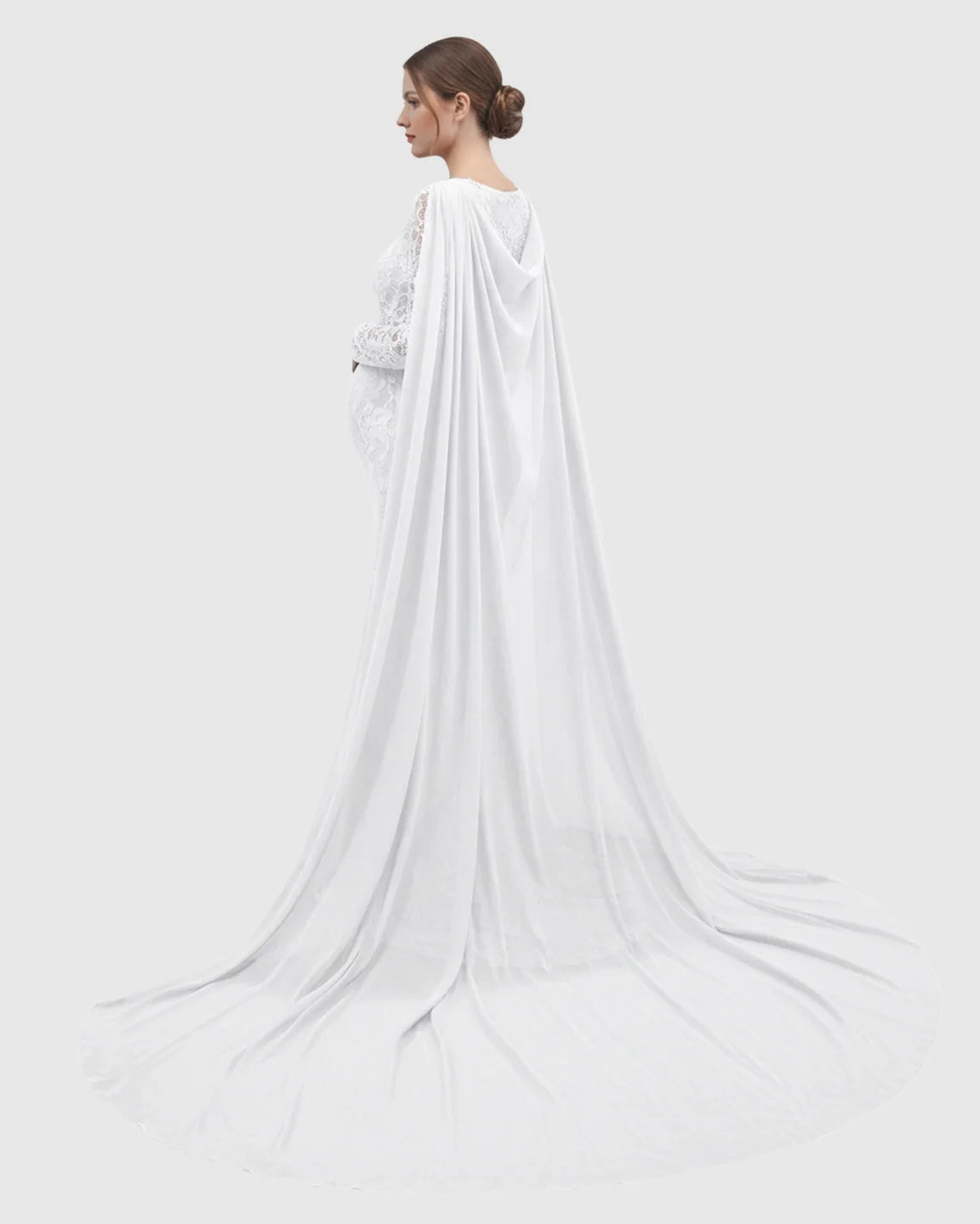 White lace maternity gown with long sleeves, empire waist, and a dramatic trailing chiffon cape.