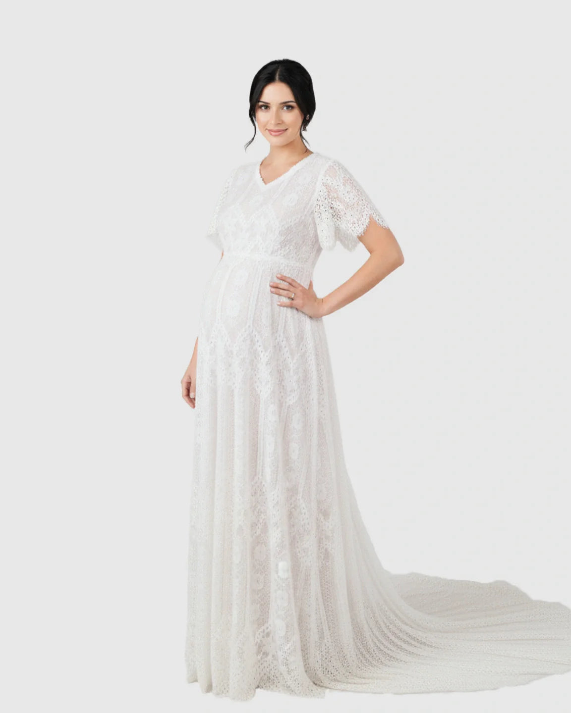 White vintage lace maternity gown with flutter sleeves, V-neck, and long trailing hem.