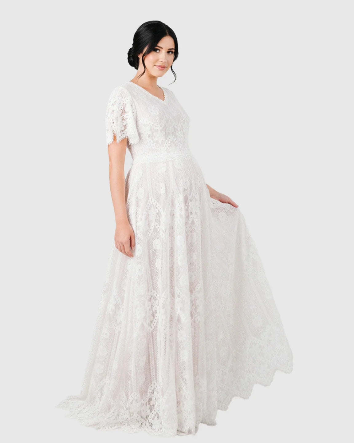 White vintage lace flutter-sleeve maternity gown with V-neck and long trailing hem.