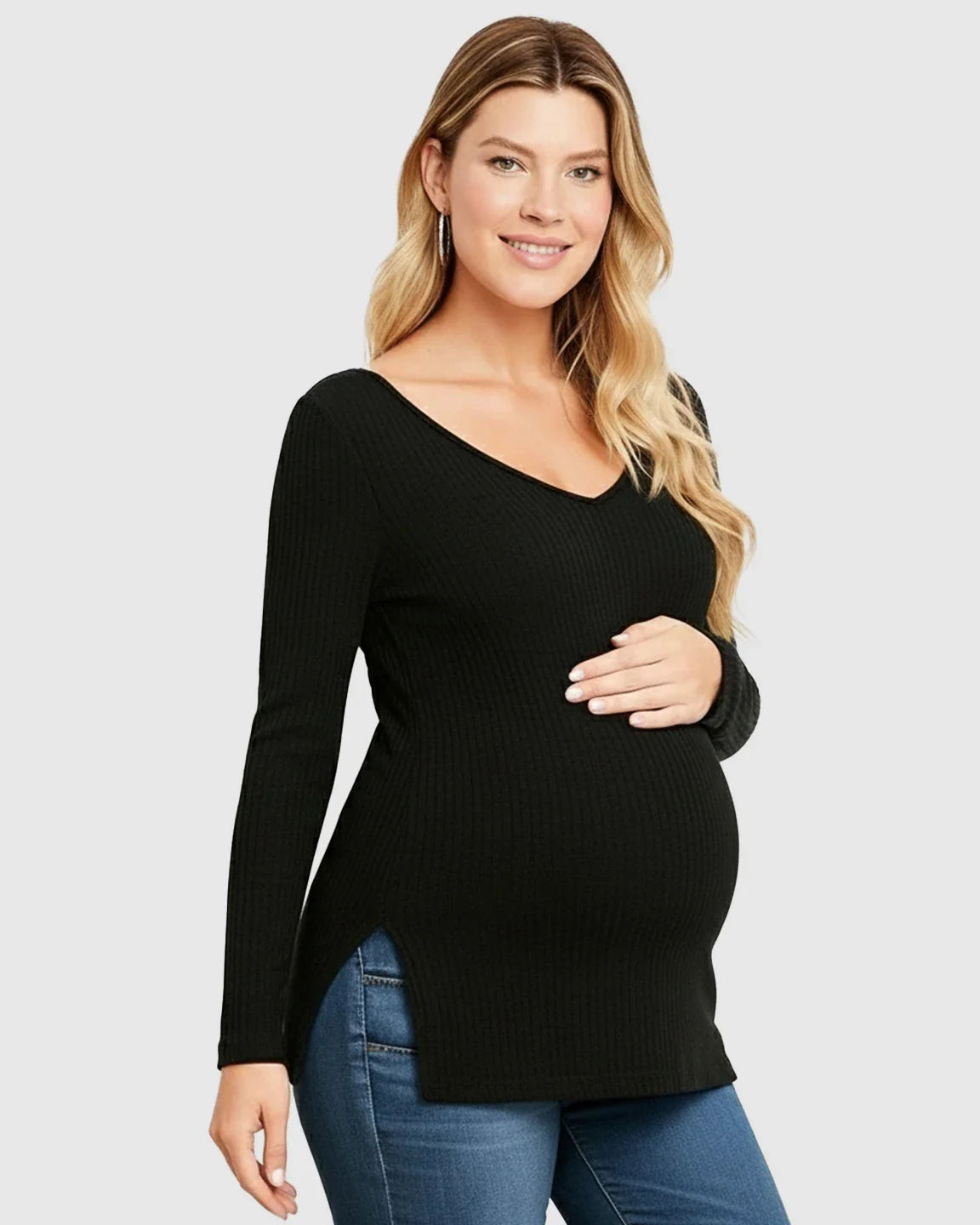 Smiling pregnant woman in a black ribbed V-neck long sleeve maternity top with side slits, paired with jeans.