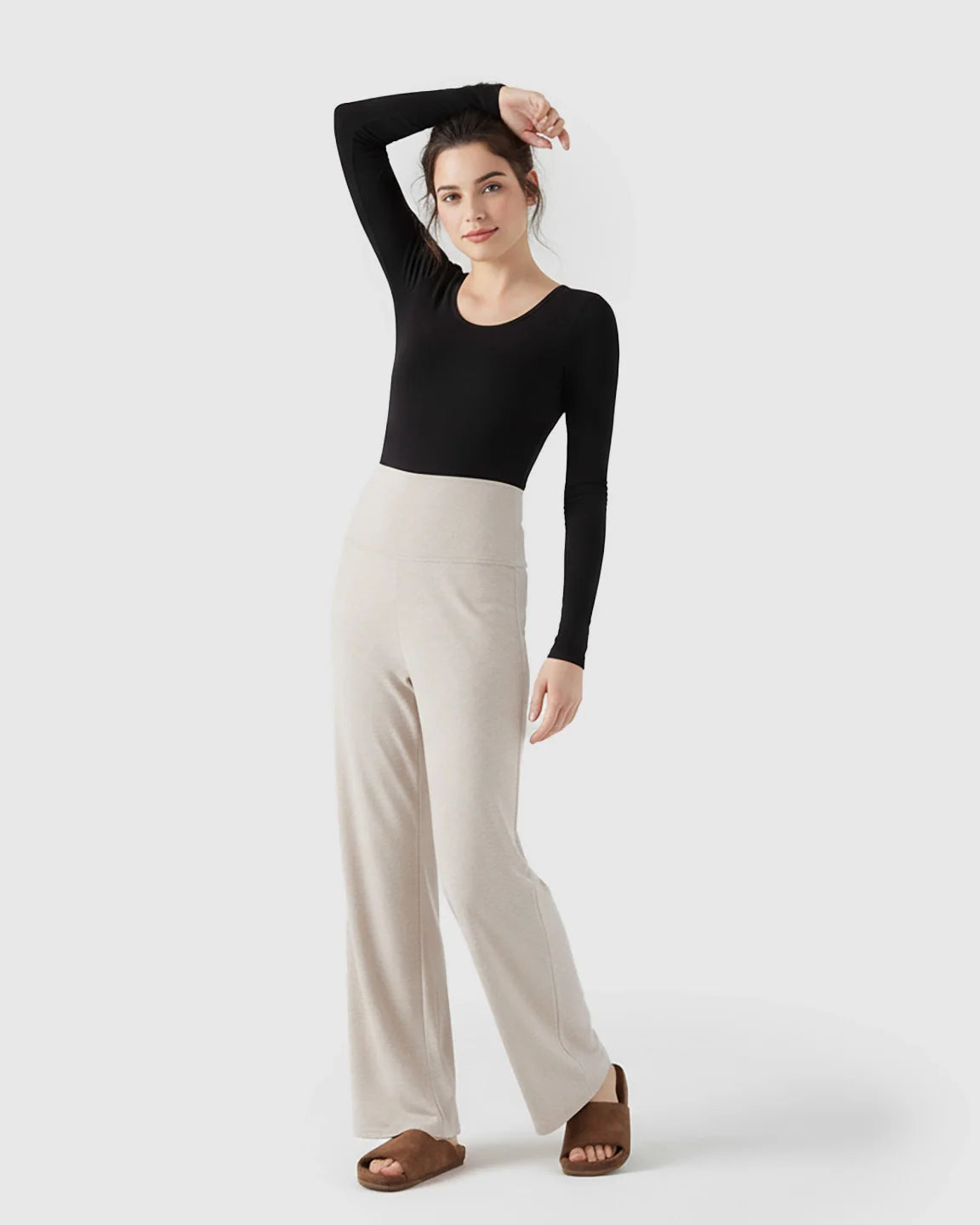 Model wears beige fleece relaxed maternity pants with an over-belly waistband and wide-leg silhouette.