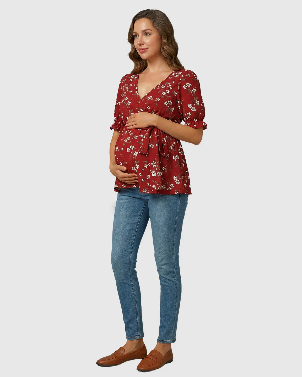 Red floral crossover V-neck maternity & nursing top with puff sleeves and tie waist, worn by a pregnant woman.