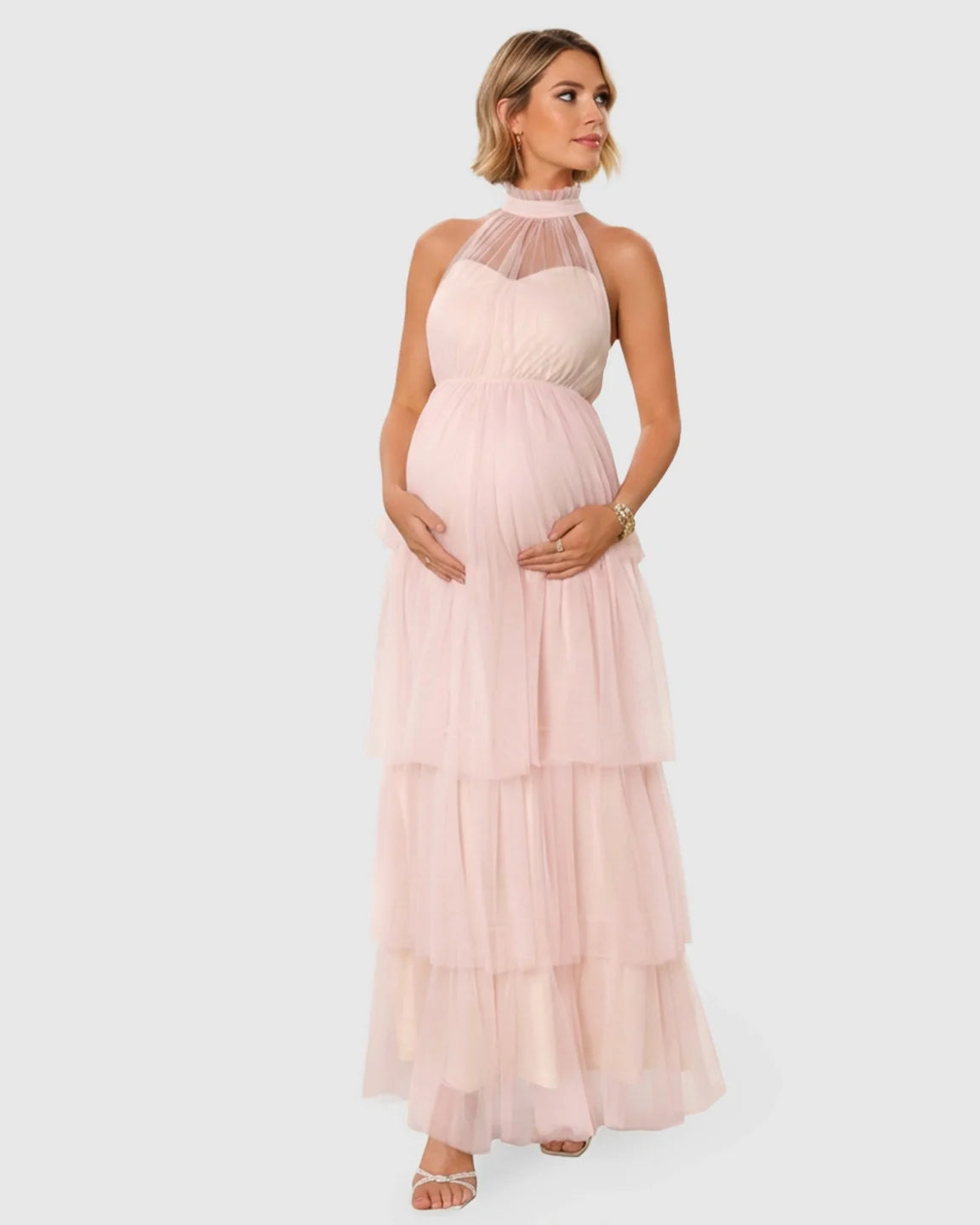 Blush pink halter neck tiered mesh maternity gown, floor-length with a romantic, cloud-like skirt.