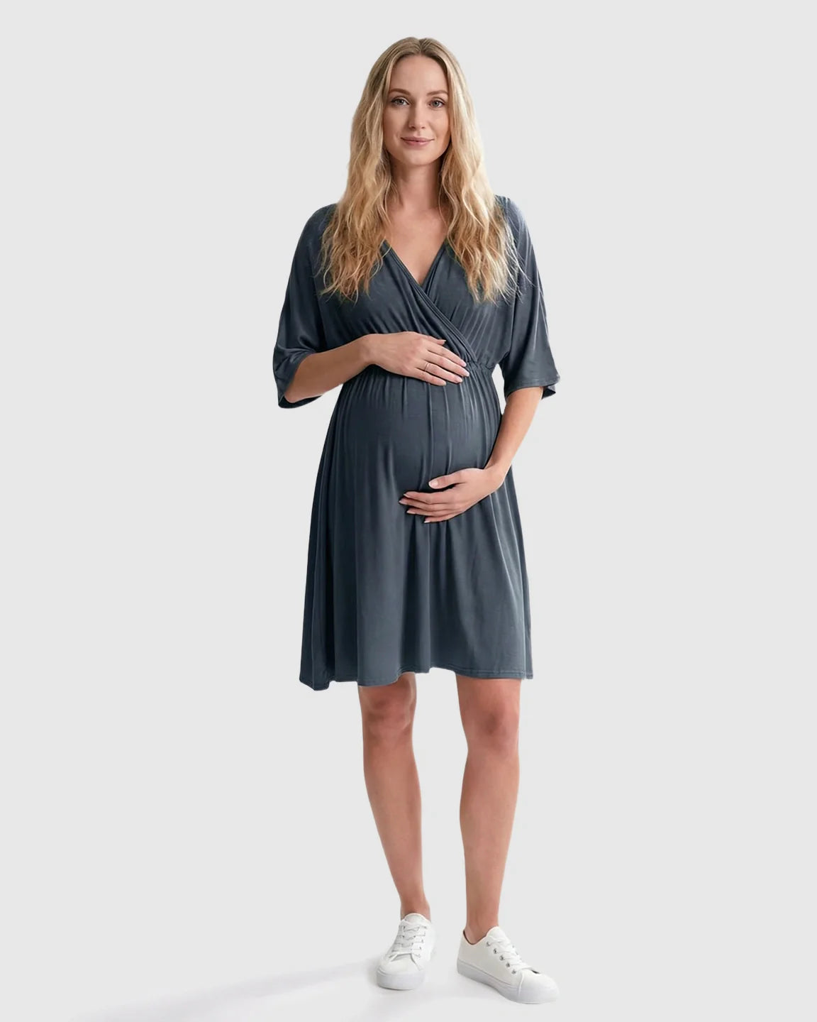 Pregnant woman in a charcoal gray cross-front maternity midi dress with elbow-length sleeves and an A-line silhouette.