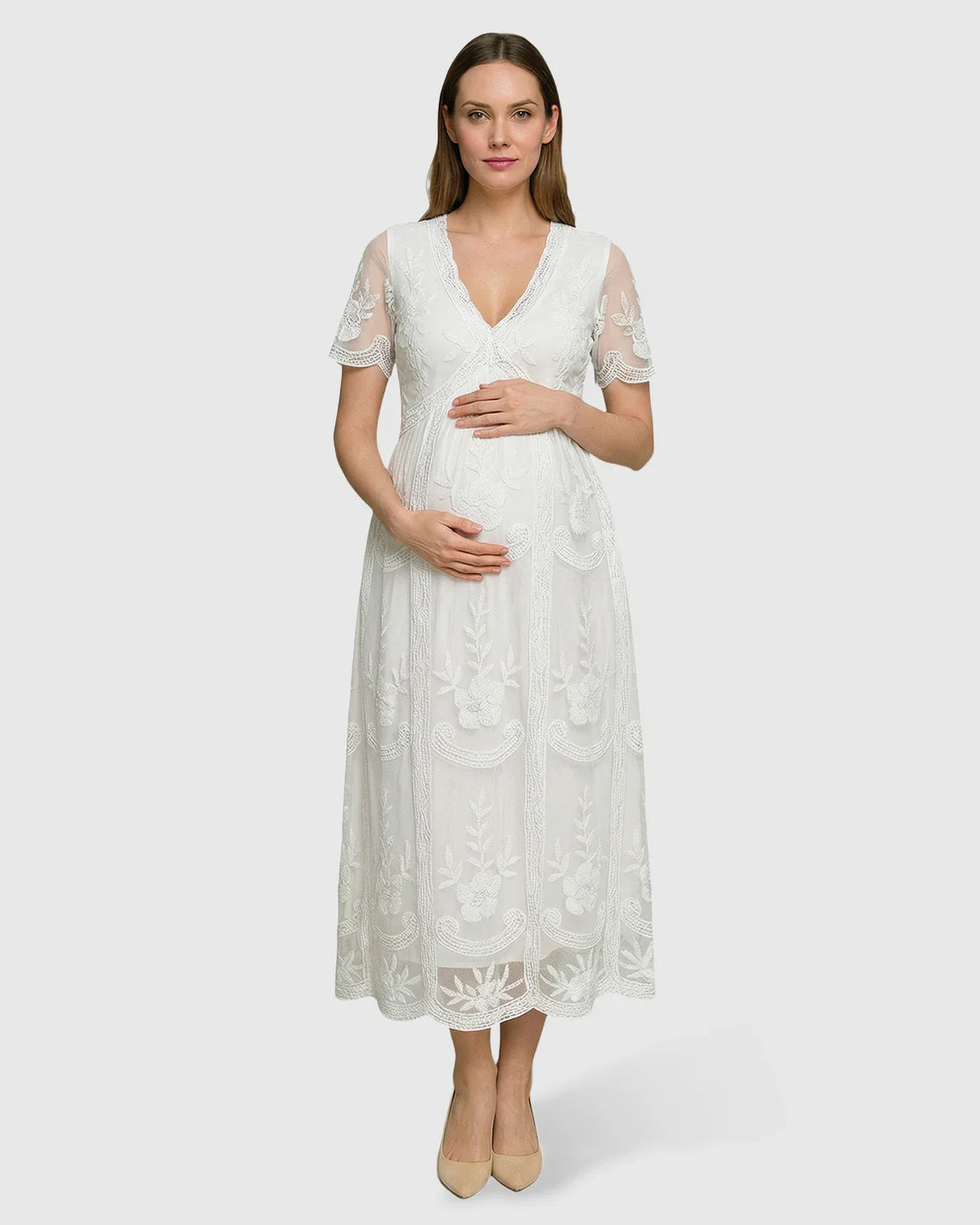 White lace maternity midi dress with V-neck, three-quarter sleeves, and floral embroidery, worn by a pregnant woman.