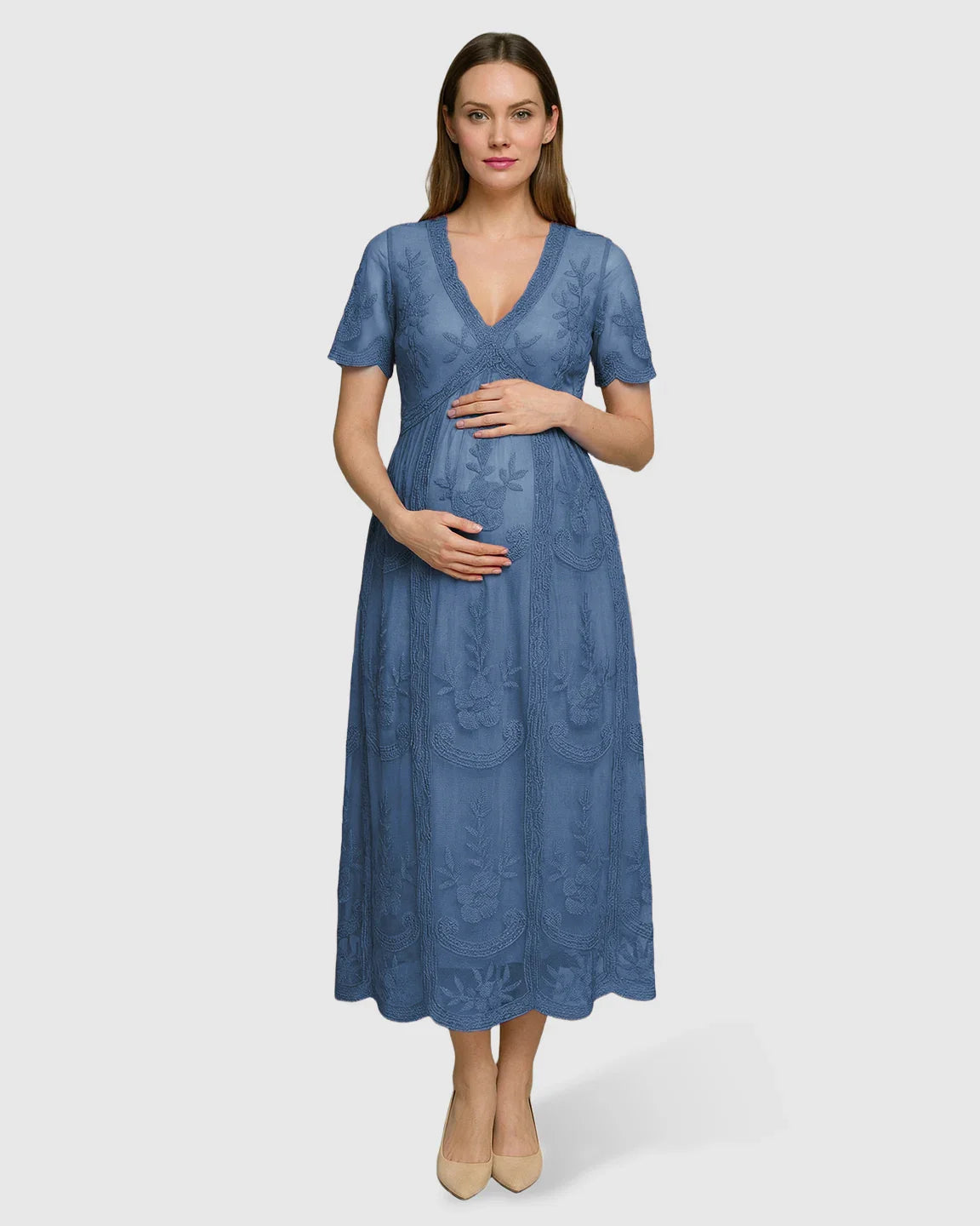 Pregnant woman in a blue lace maternity midi dress with V-neck, three-quarter sleeves, and floral embroidery.