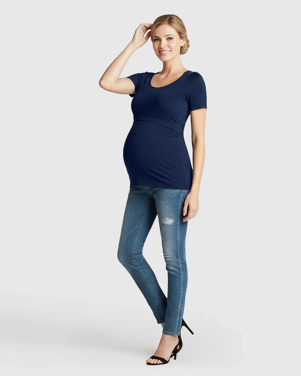 Smiling pregnant woman in a navy stretch-fit V-neck nursing t-shirt and jeans.
