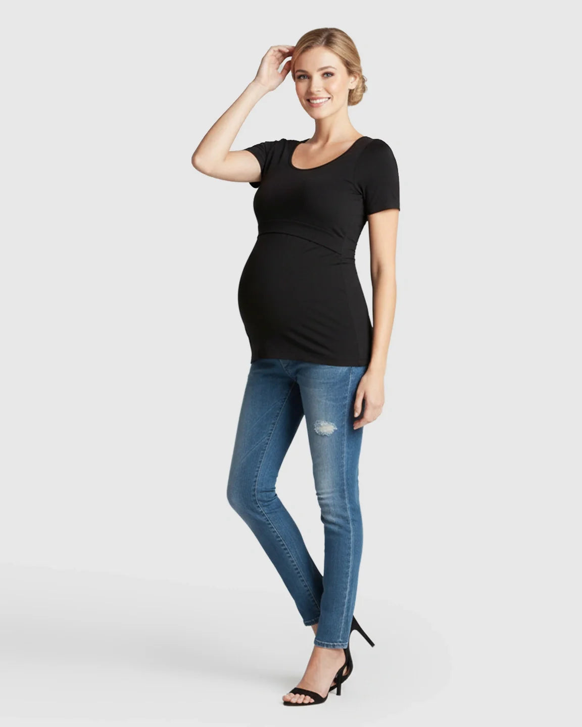Smiling pregnant woman in a black stretch-fit V-neck nursing t-shirt and jeans.