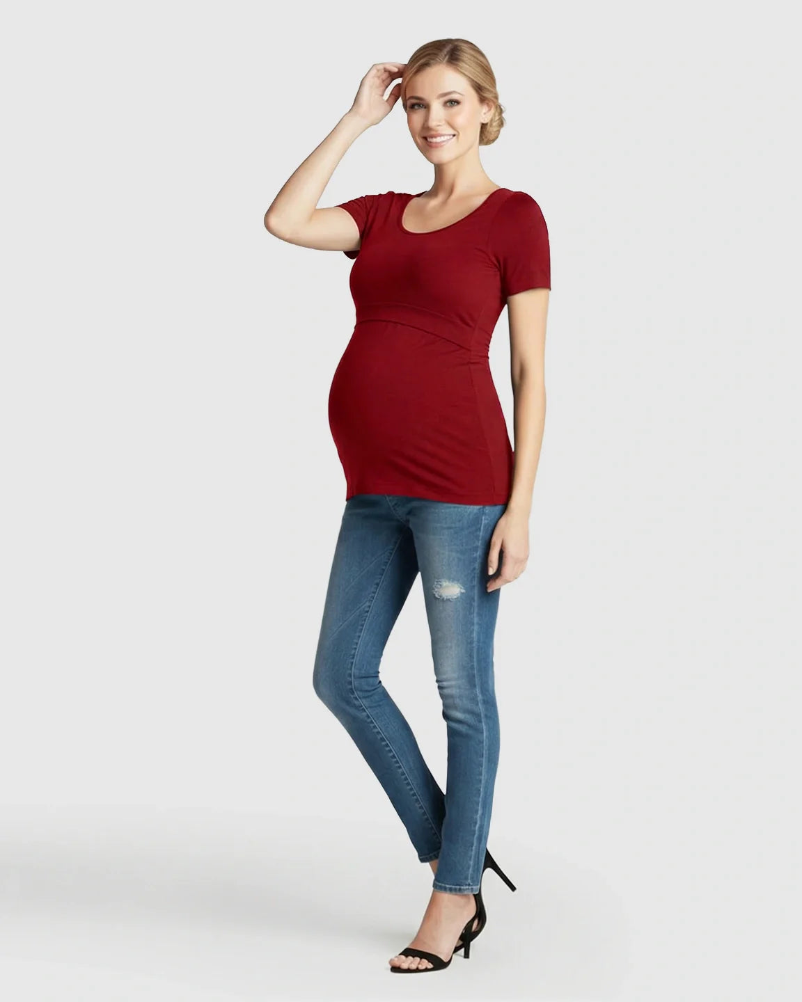 Smiling pregnant woman in a red stretch-fit v-neck nursing t-shirt and jeans.