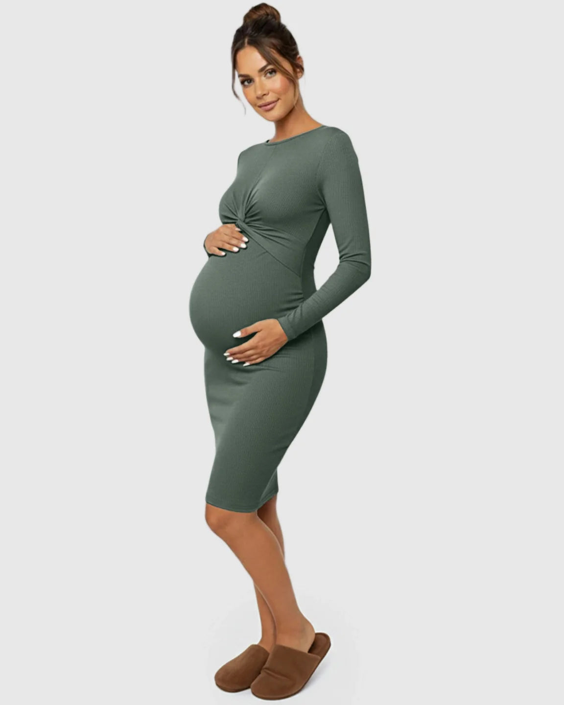 Maternity model in a dark olive green ribbed bodycon dress with a twist-front detail and long sleeves.