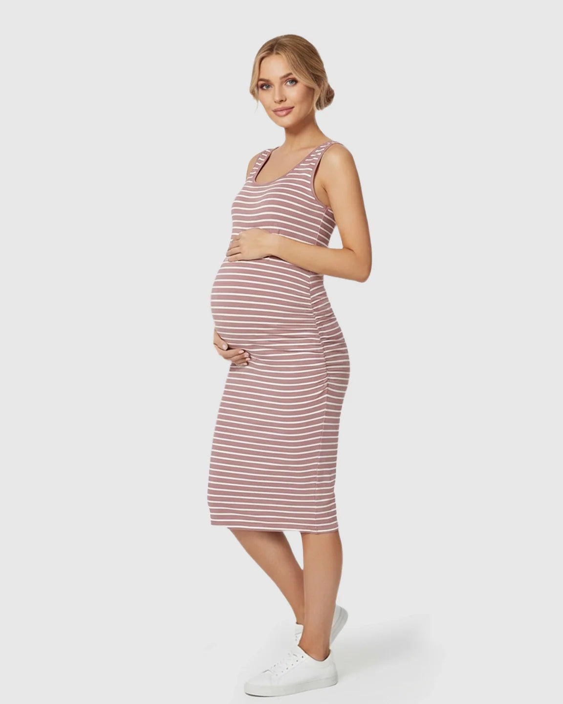 Maternity model in a pink and white striped sleeveless bodycon dress, hugging her baby bump.
