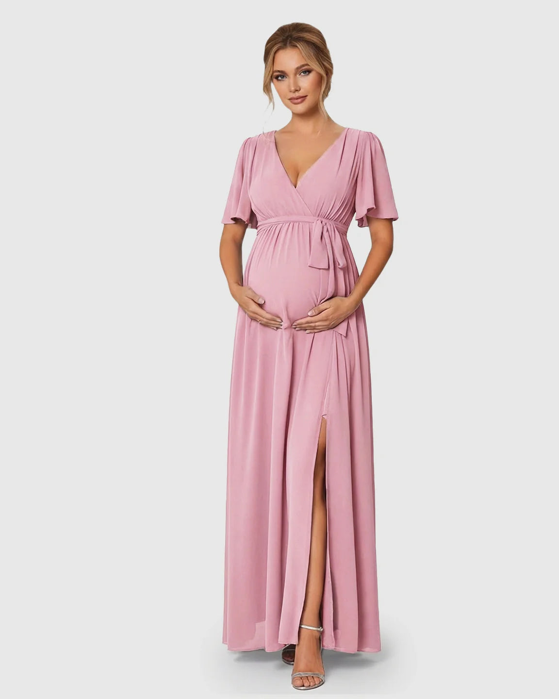 Pink V-neck flutter sleeve maternity maxi dress with empire waist tie and front slit.