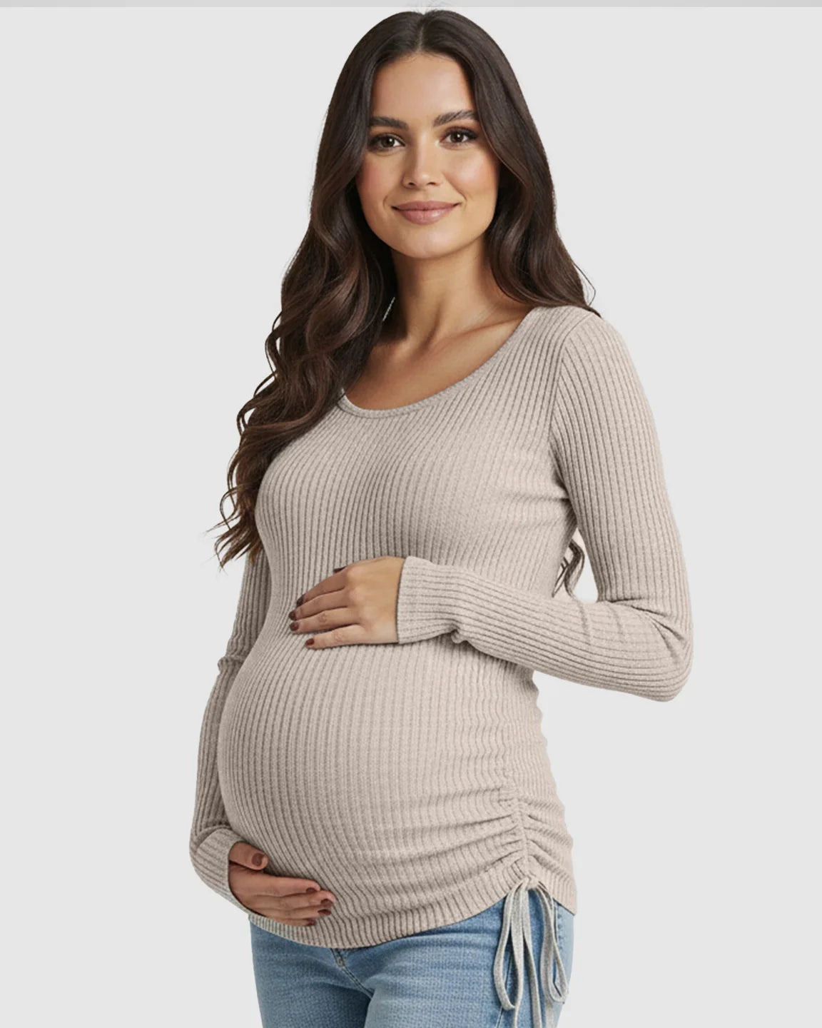 Pregnant woman in a beige ribbed maternity top with adjustable side drawstrings and a U-neck.